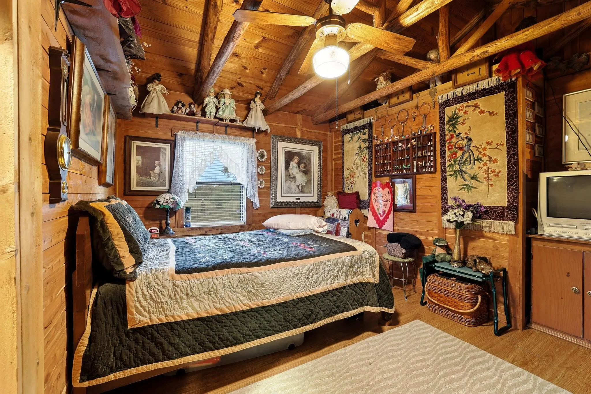 This room features wood-paneled walls and a sloped ceiling with exposed wood beams