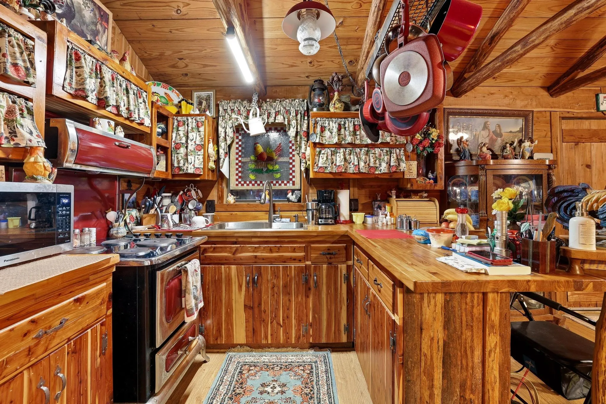 The kitchen features extensive wooden cabinetry and countertops, a stainless steel sink, and a classic range oven