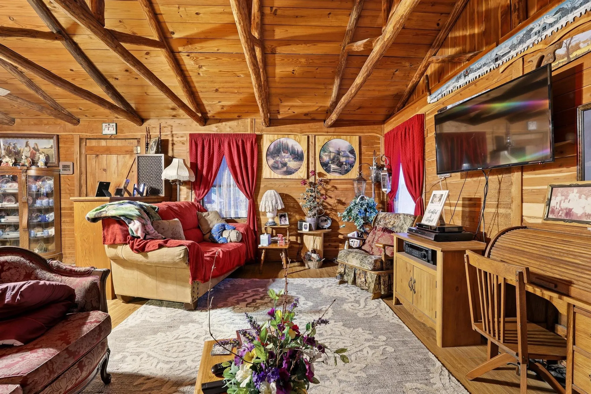 This property features an inviting living area with natural wood paneling throughout, including exposed beams on the vaulted ceiling