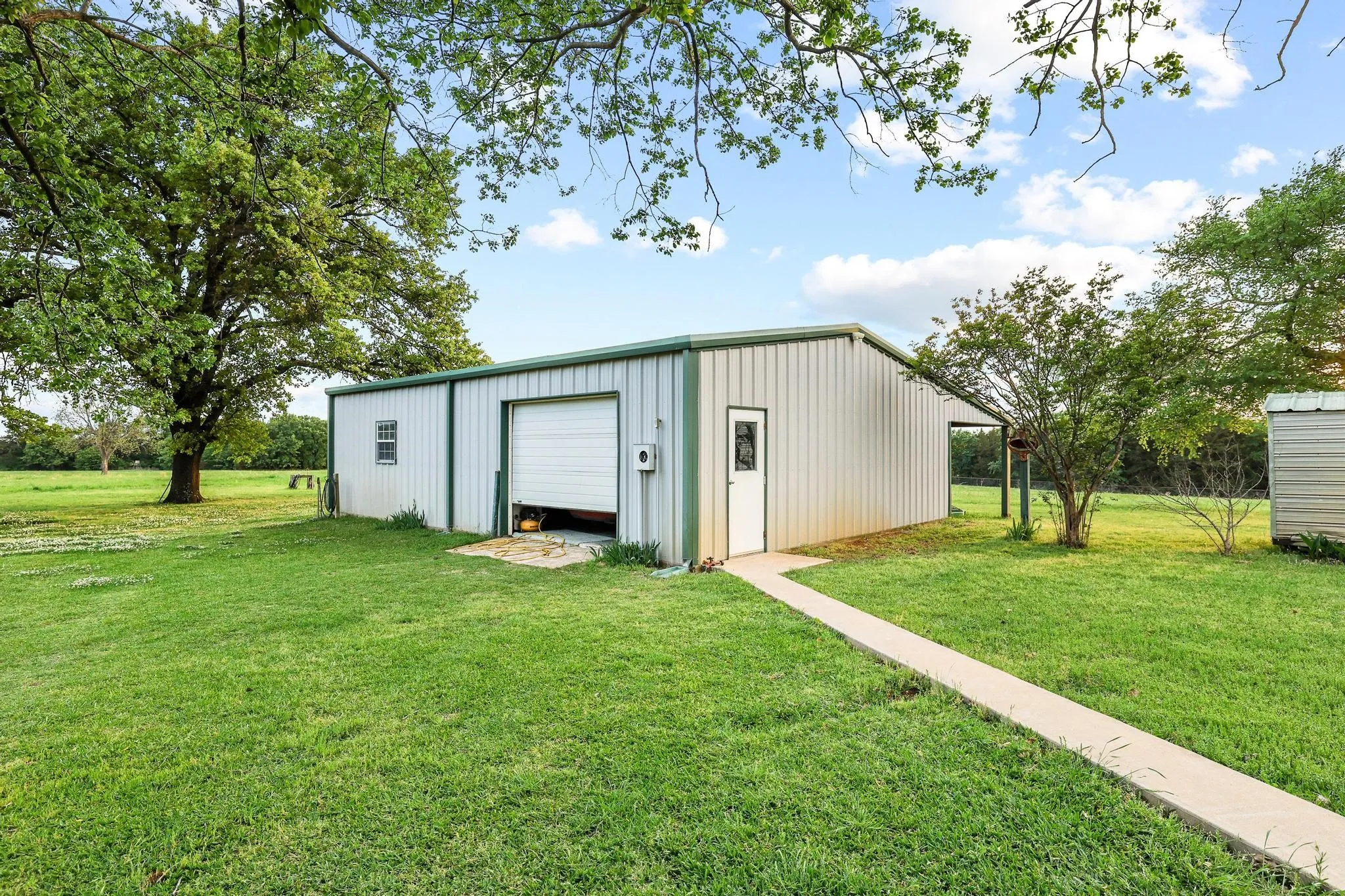 This property features a metal building with a roll-up garage door and a side entry door