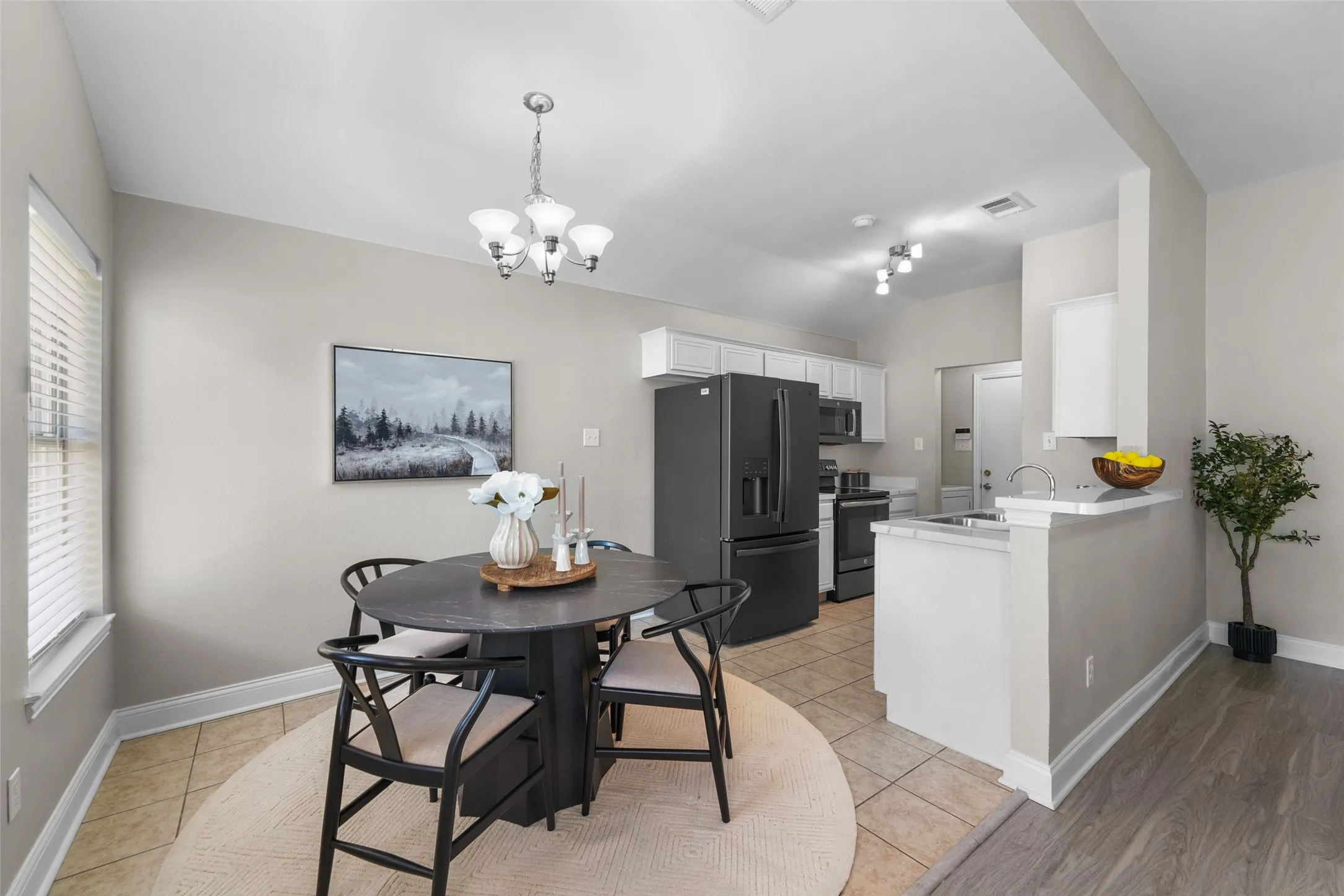 Virutally staged. Dining space featuring light tile patterned floors, suspended lighting, and lofted ceiling