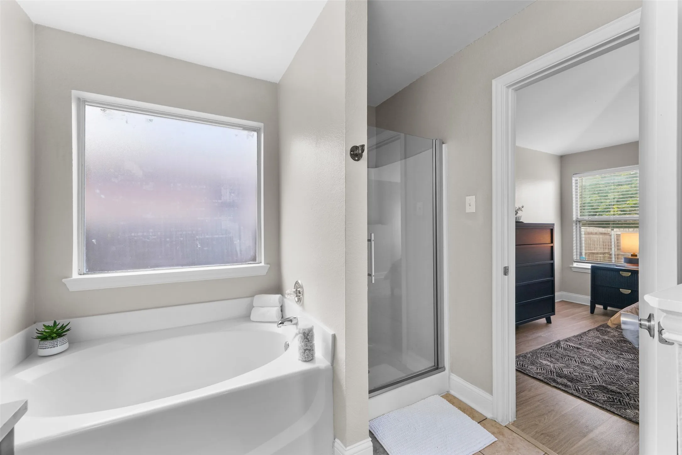 Full bath with a shower stall, a garden tub, vanity, and light wood finished floors