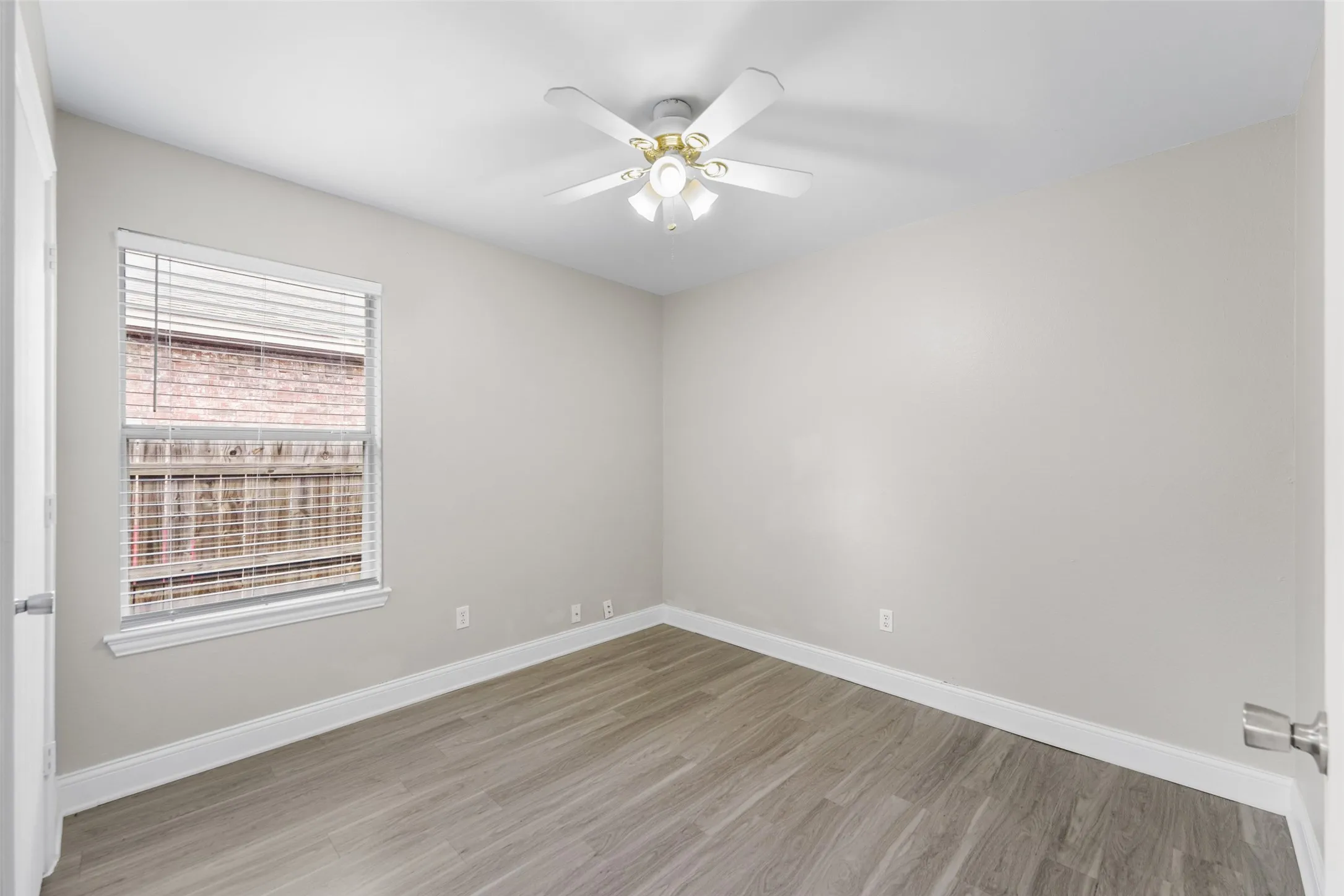 Spare room with light wood finished floors and ceiling fan