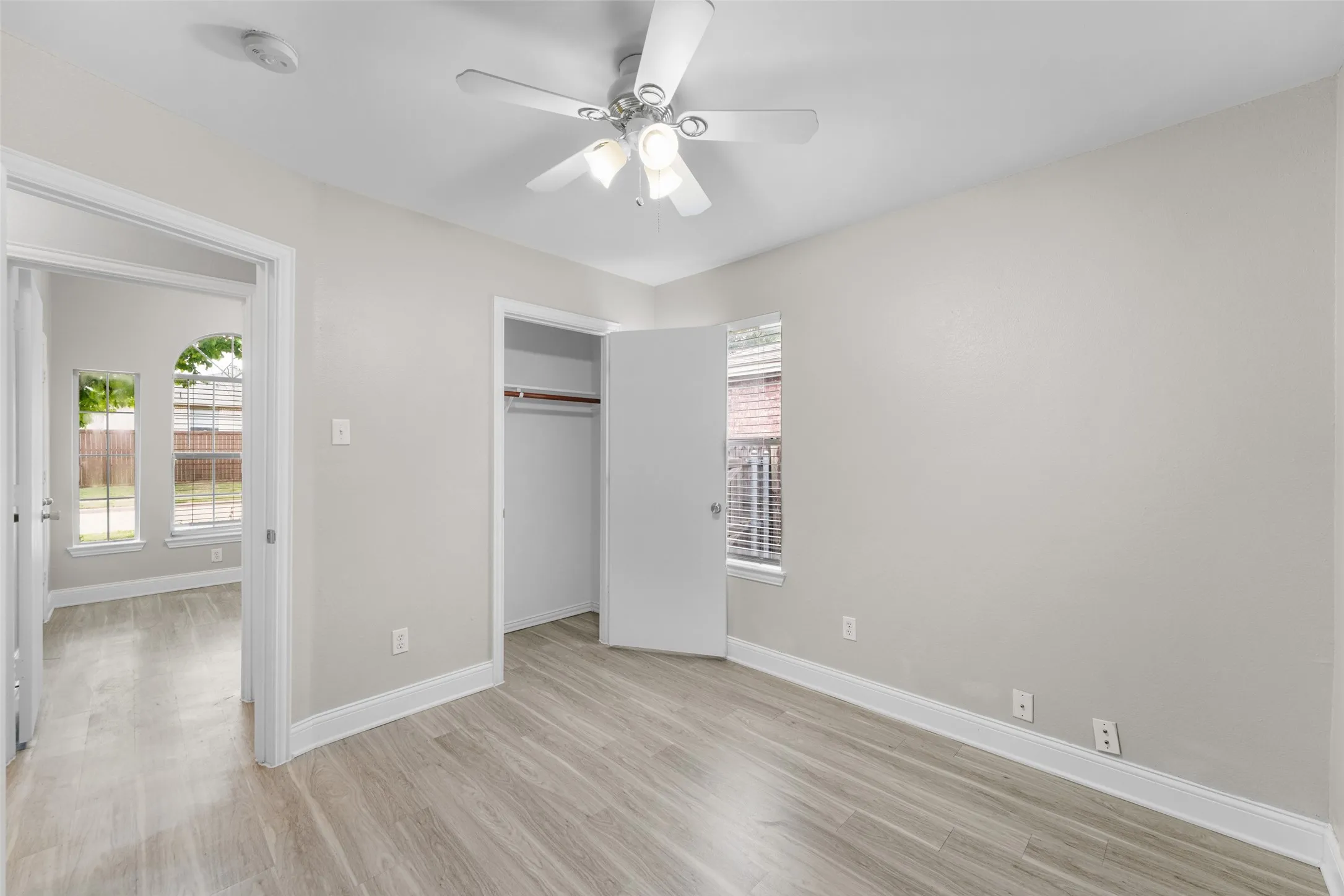 Unfurnished bedroom featuring light wood-style flooring, a ceiling fan, and a closet