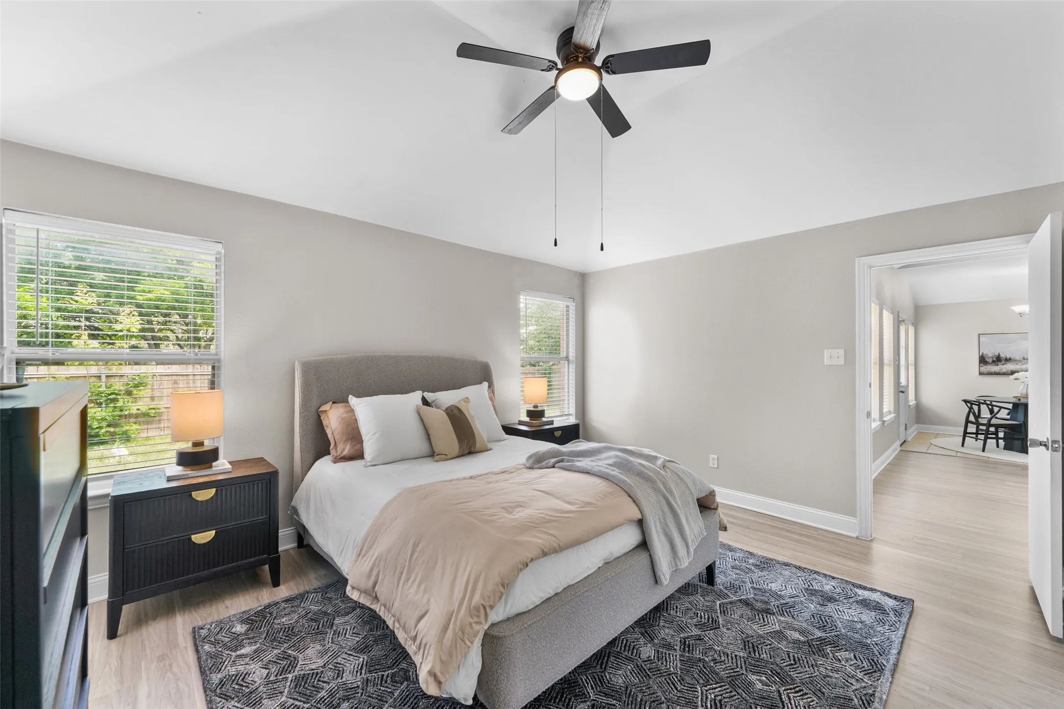Bedroom with vaulted ceiling, ceiling fan, and light wood finished floors