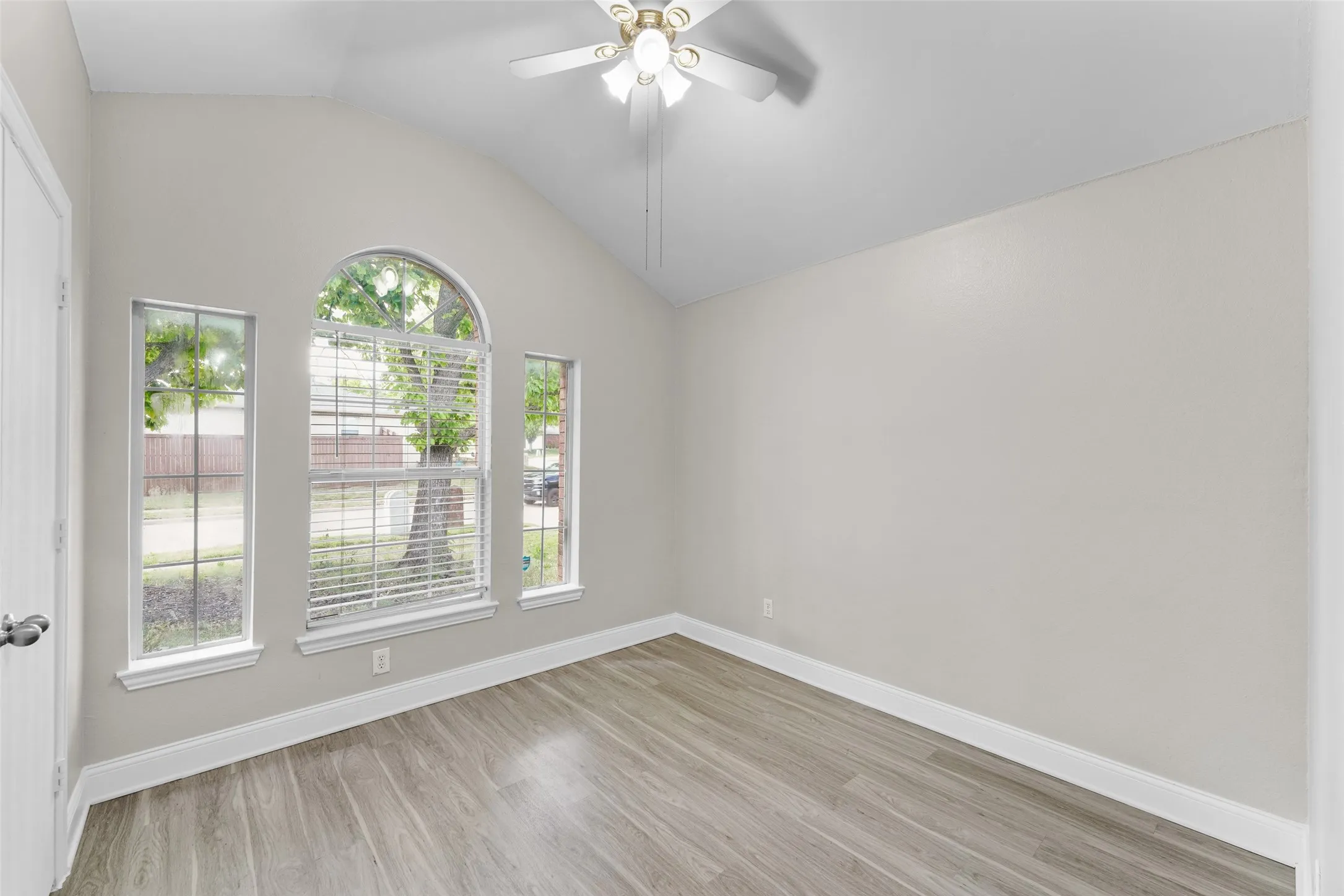 Unfurnished room with ceiling fan, light wood-style flooring, and vaulted ceiling