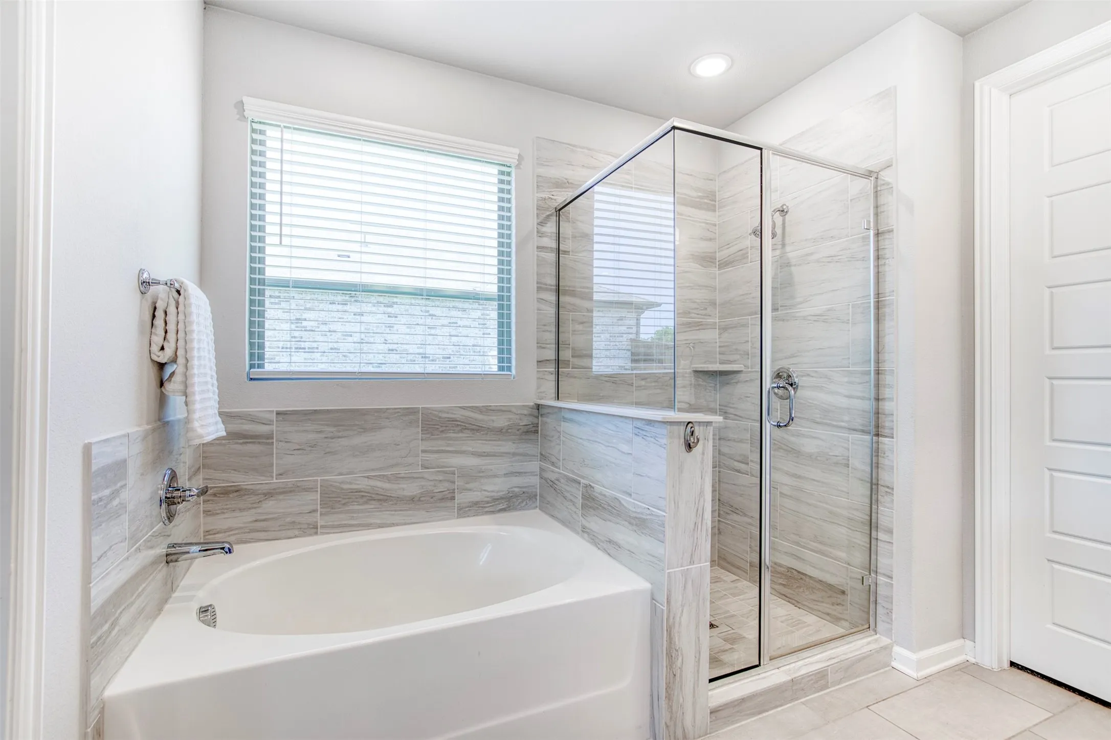 En-suite bath with soaking tub and framed shower.