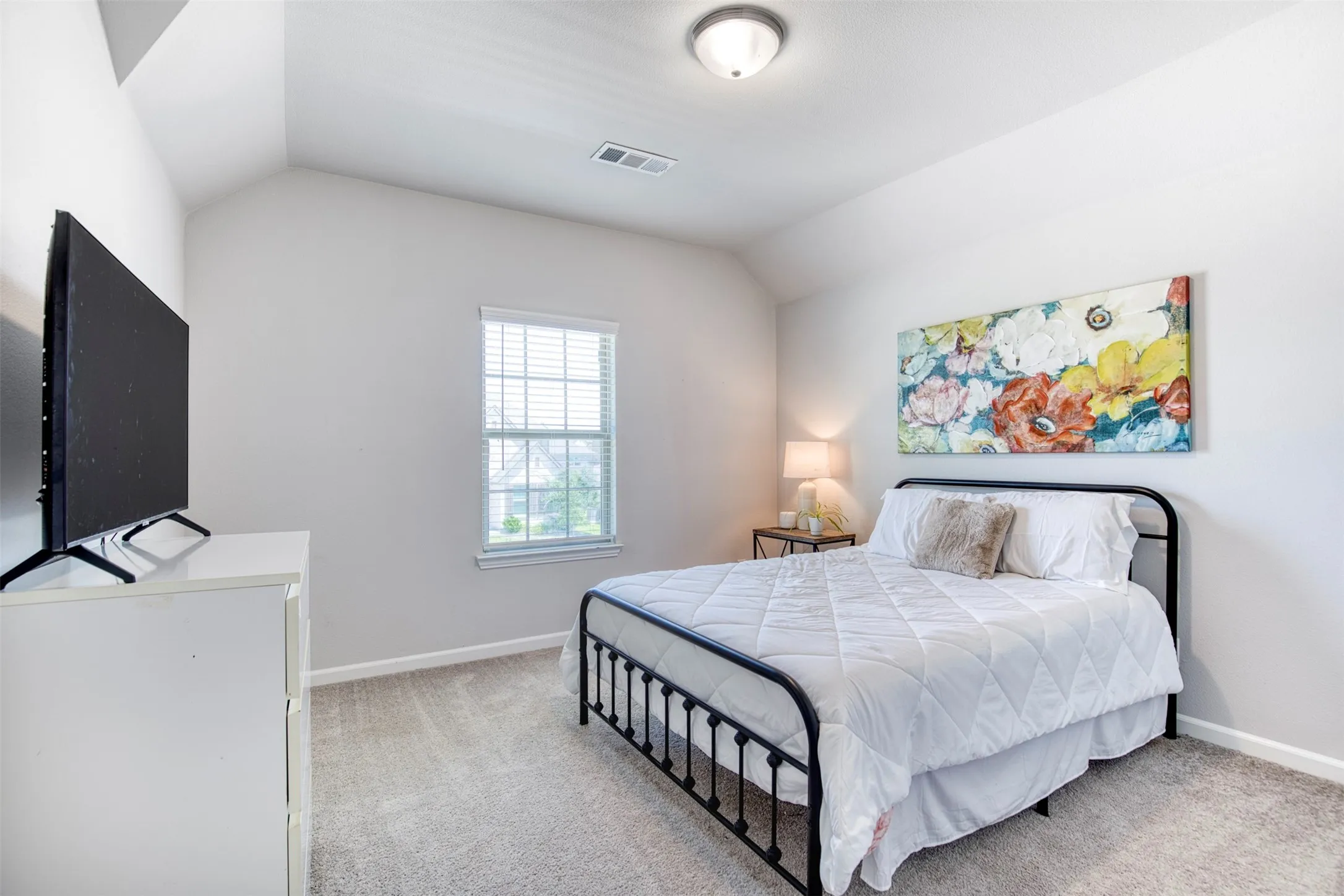 Secondary upstairs bedroom with sloped ceiling.