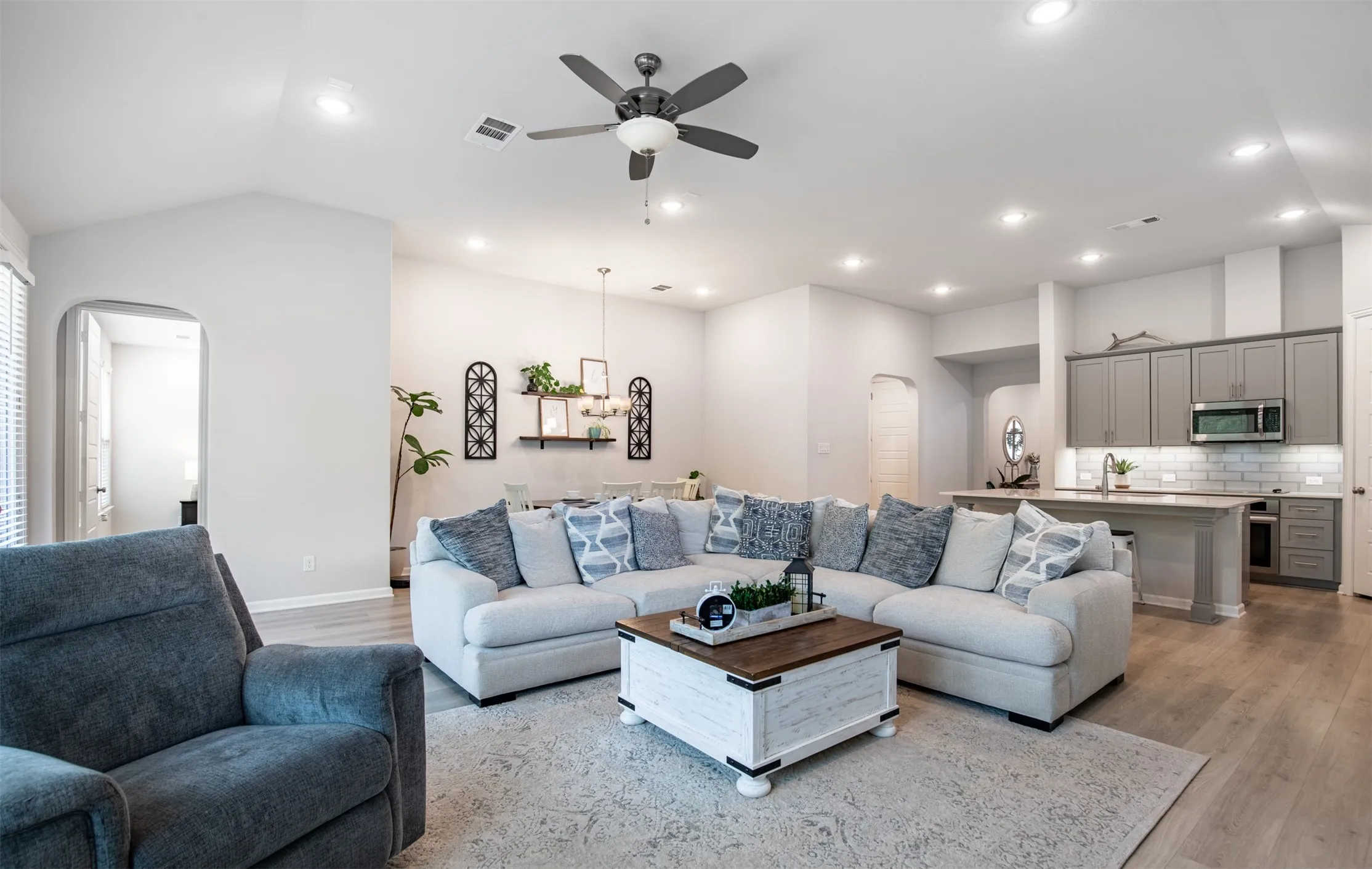 Living room with recessed lighting, ceiling fan, and natural light.