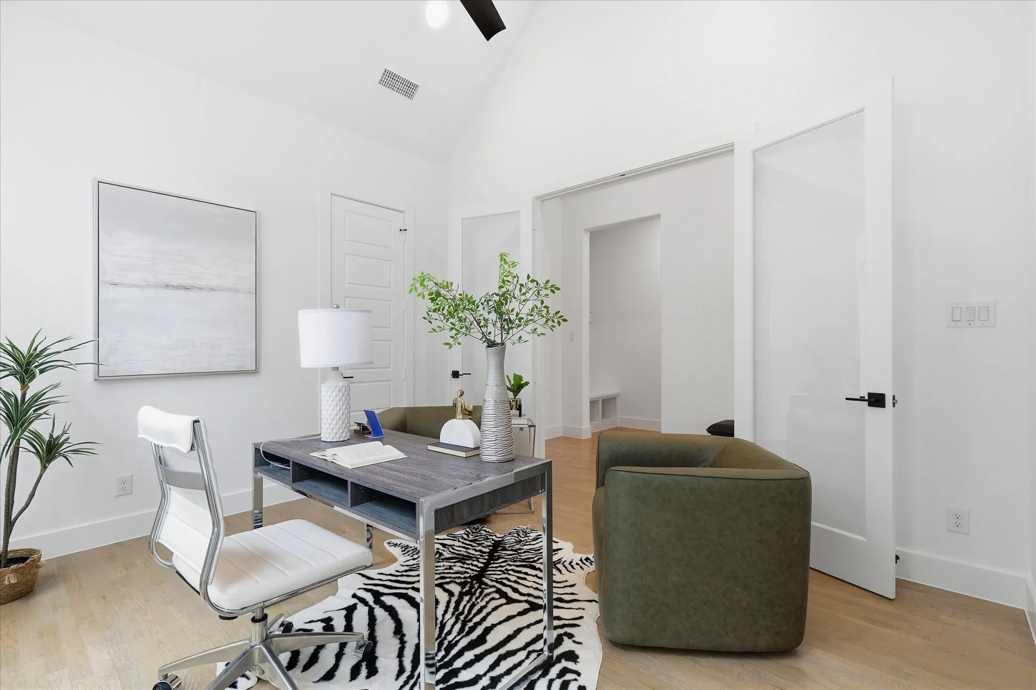 This versatile space features light wood flooring, white walls, and a vaulted ceiling