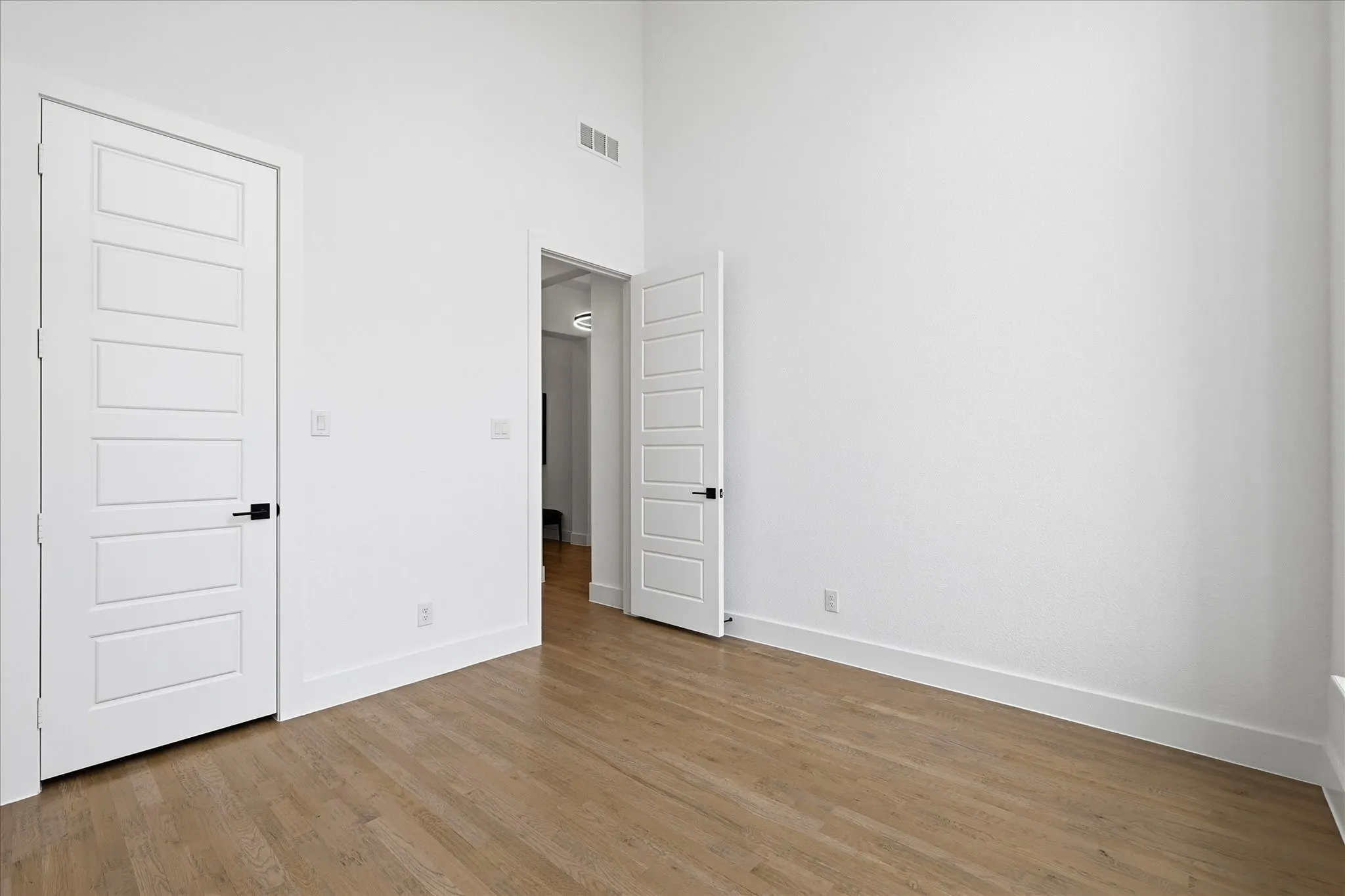 This room features light hardwood flooring, white walls, and white trim