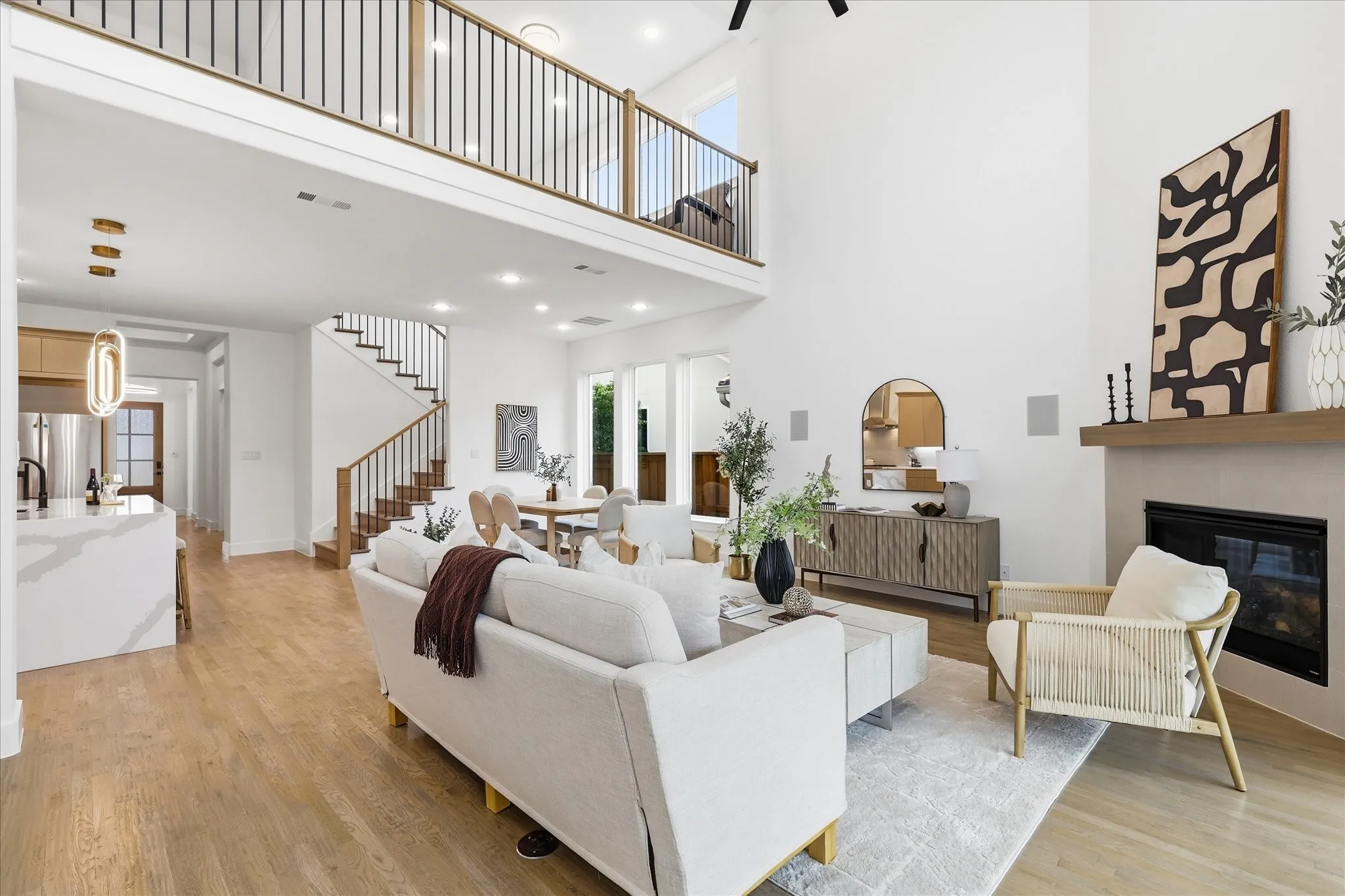 The main living area of the property features high ceilings, hardwood flooring, and a fireplace with a light-toned mantel