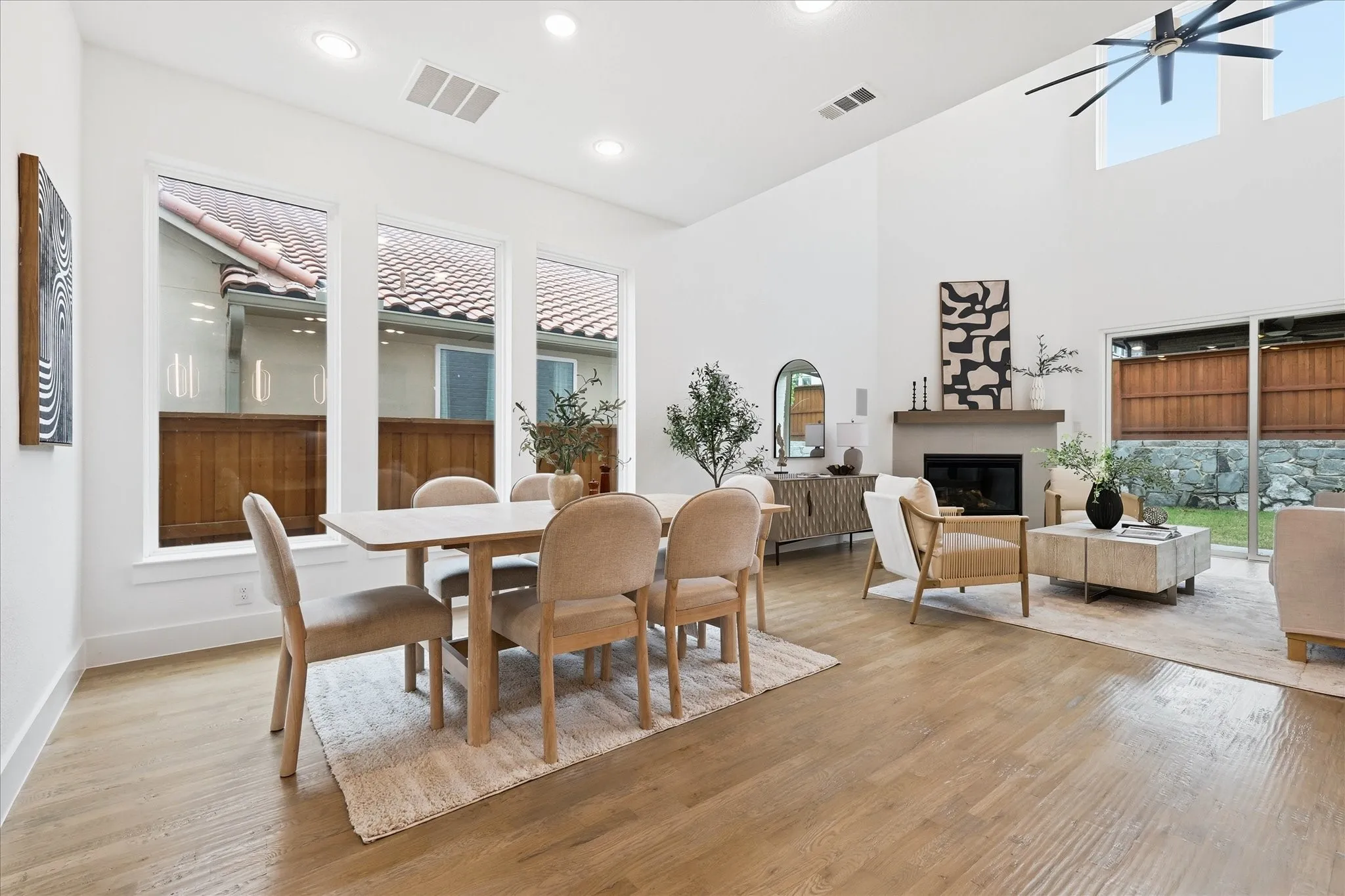 This property features an open-concept living area with high ceilings, recessed lighting, and light hardwood flooring