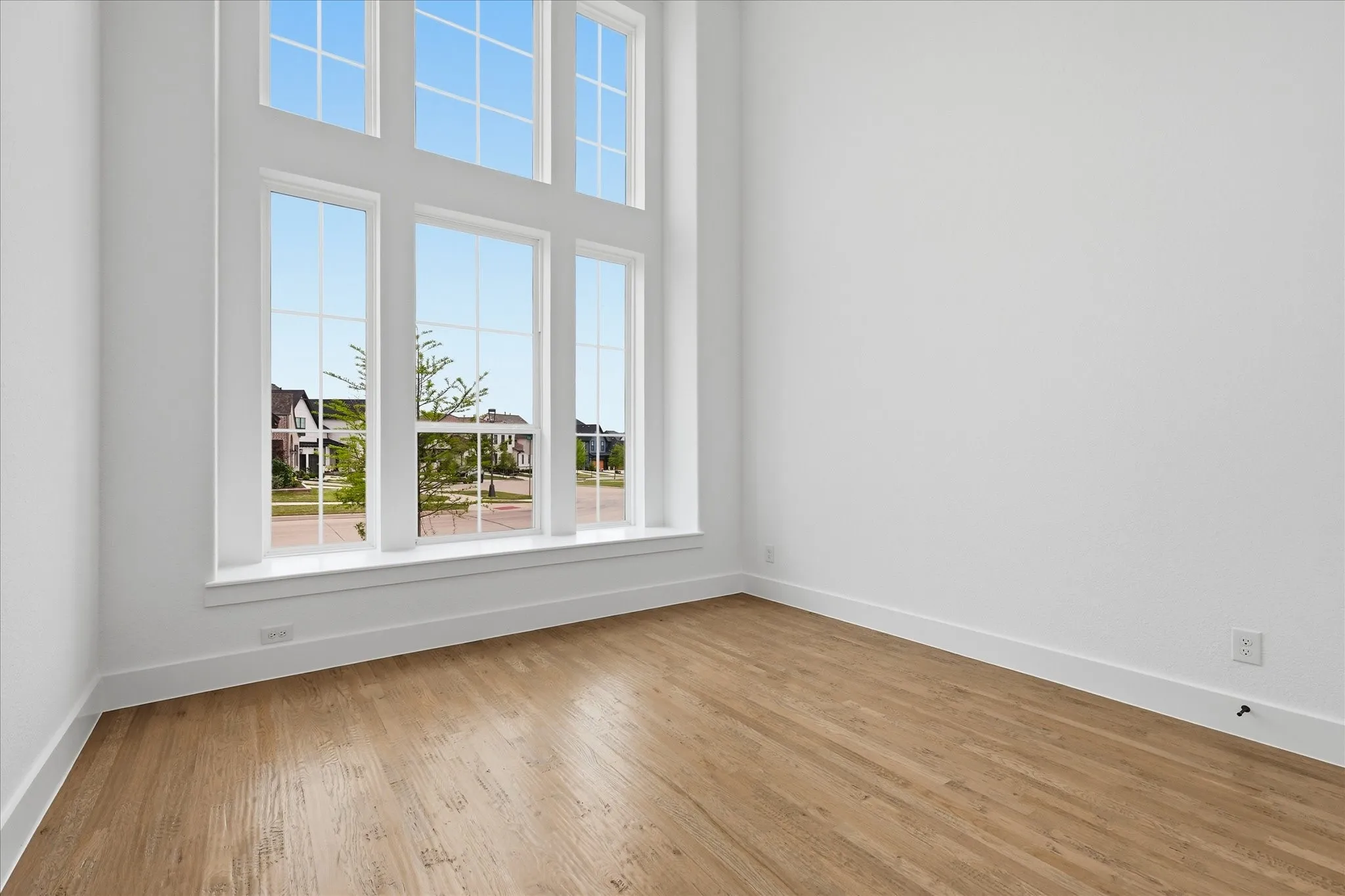 This room features an expansive multi-pane window that extends from floor to ceiling, providing abundant natural illumination
