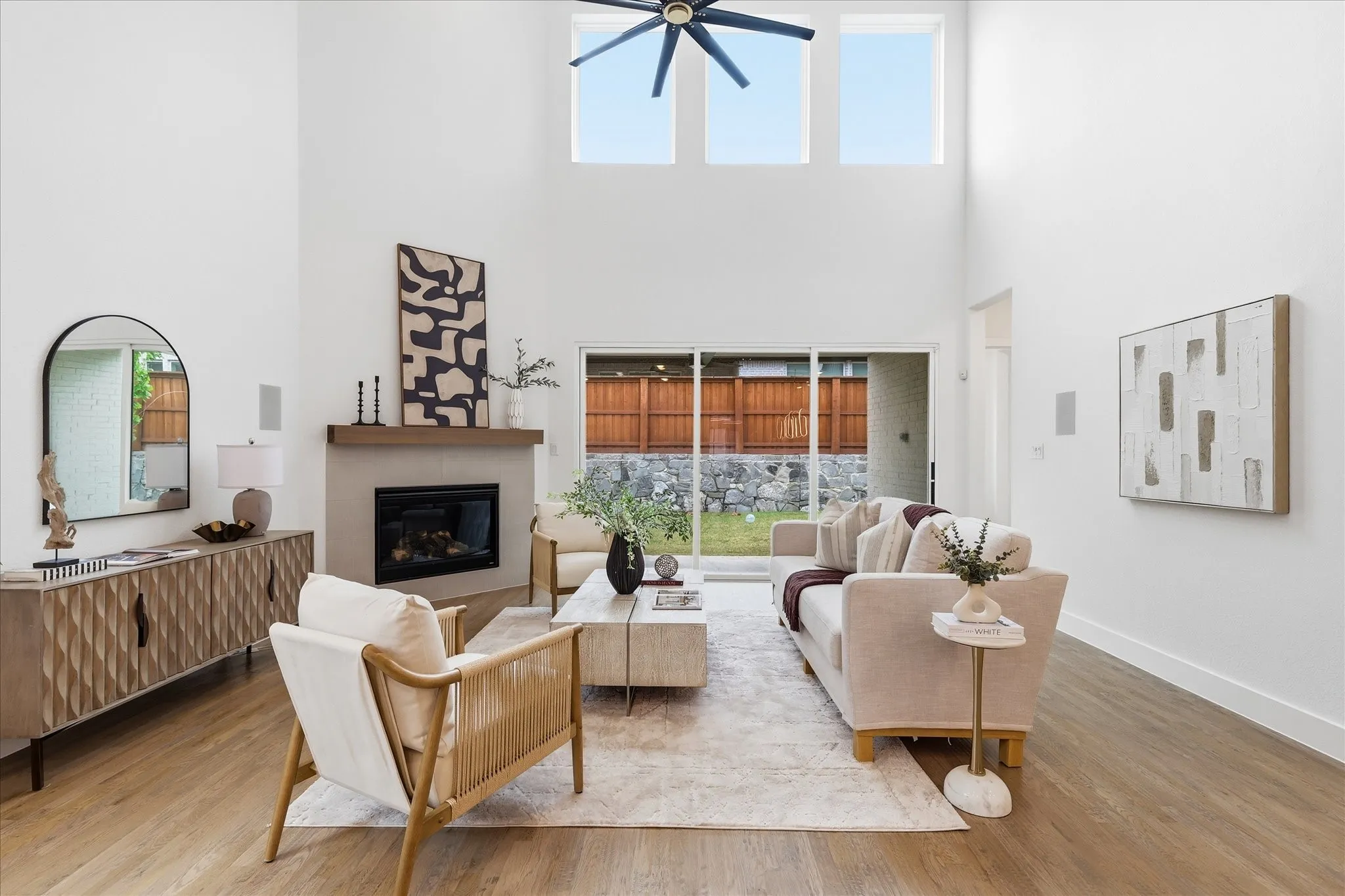 The living area features high ceilings, hardwood floors, and a fireplace with a mantel