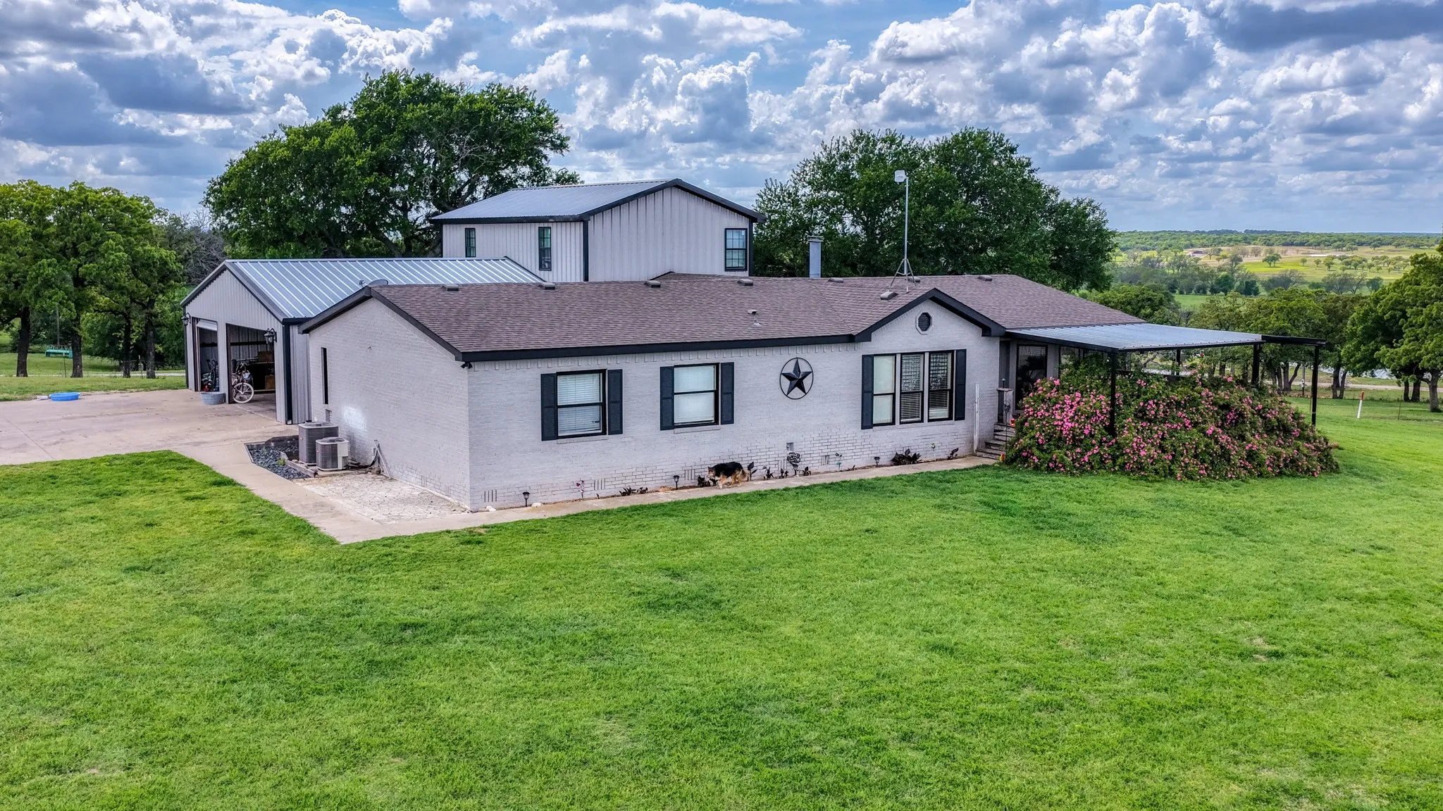 The property features a ranch-style house with a covered patio and an expansive green lawn