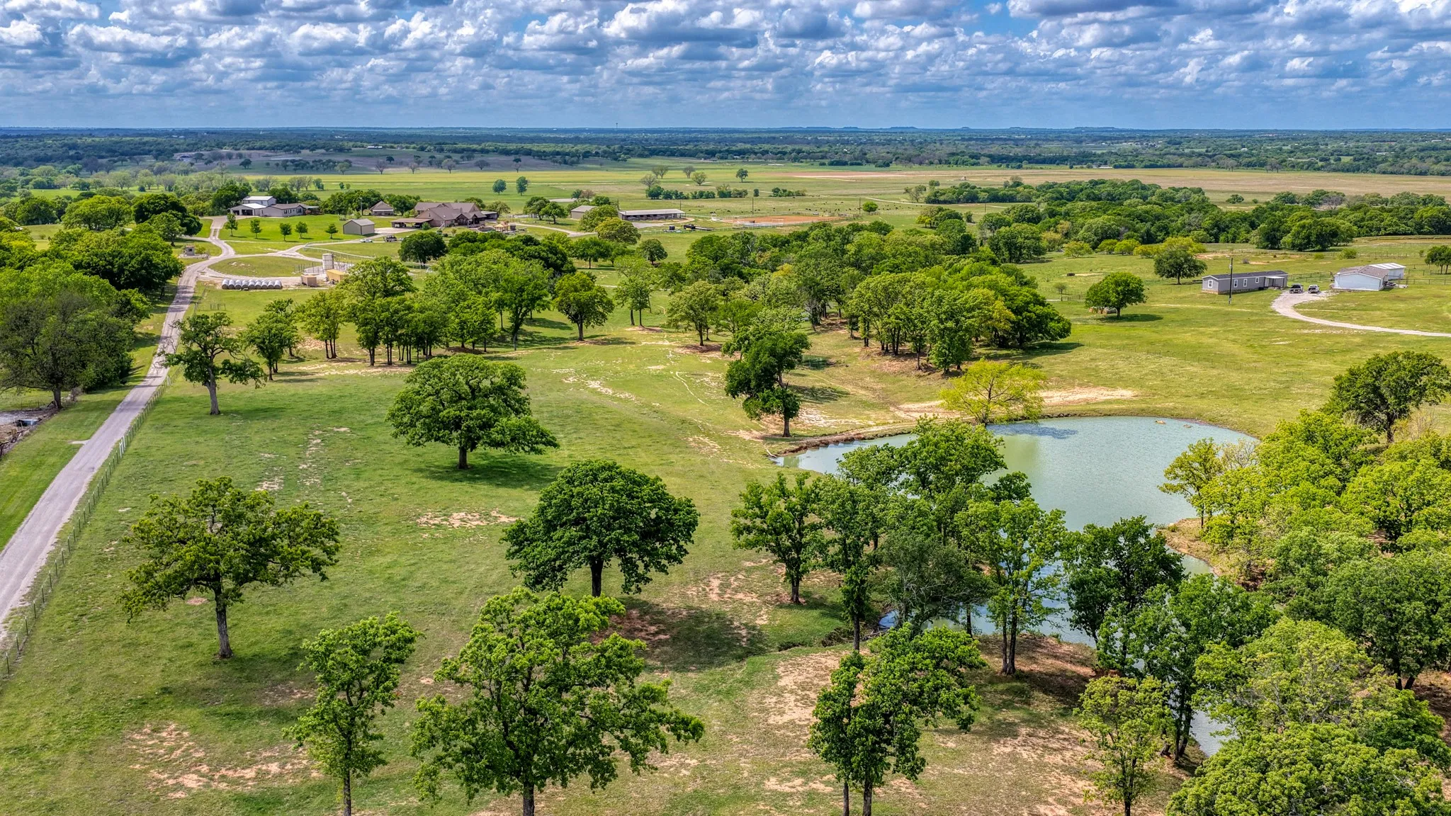 Expansive property featuring a private pond, mature trees, and vast green spaces