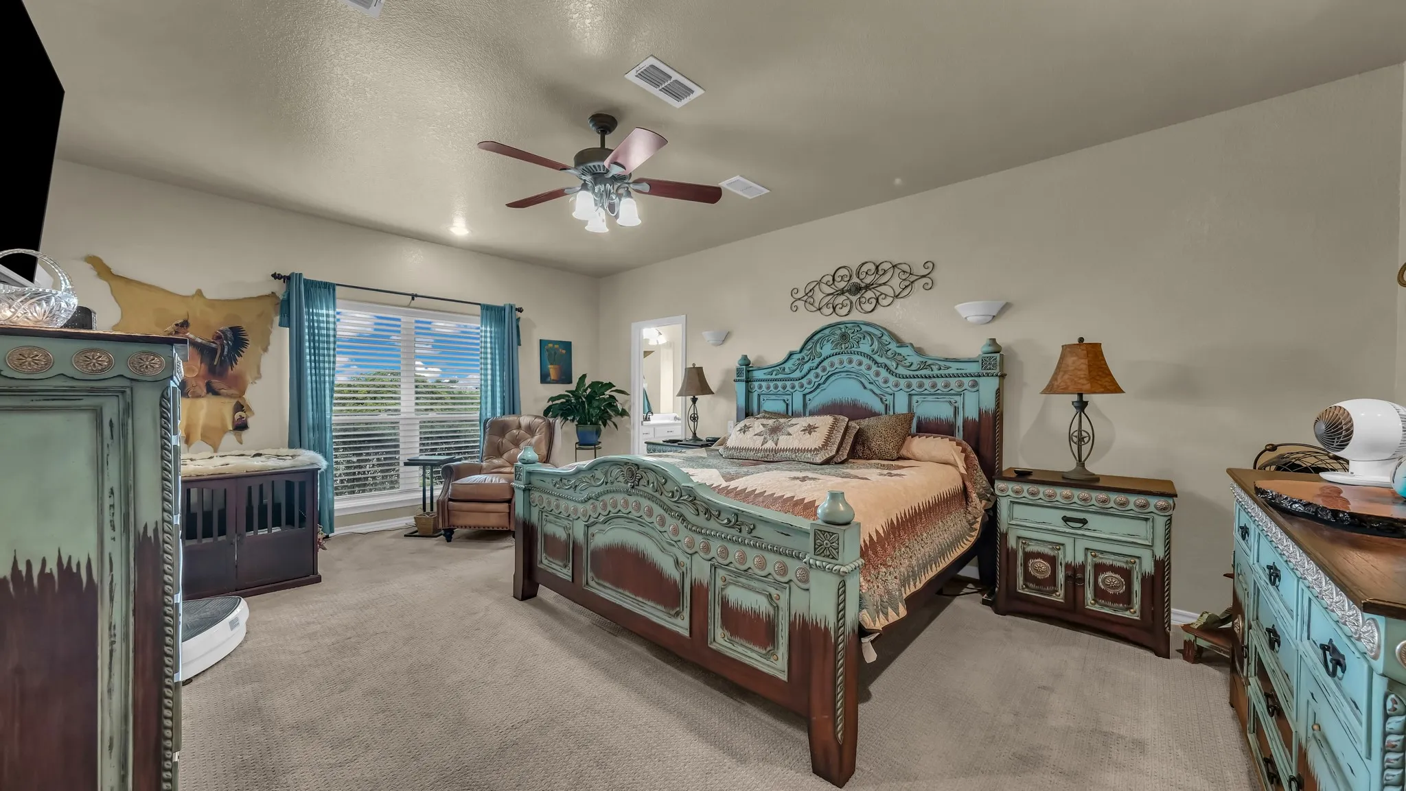 This spacious room features carpeted floors, a ceiling fan, and a large window with horizontal blinds