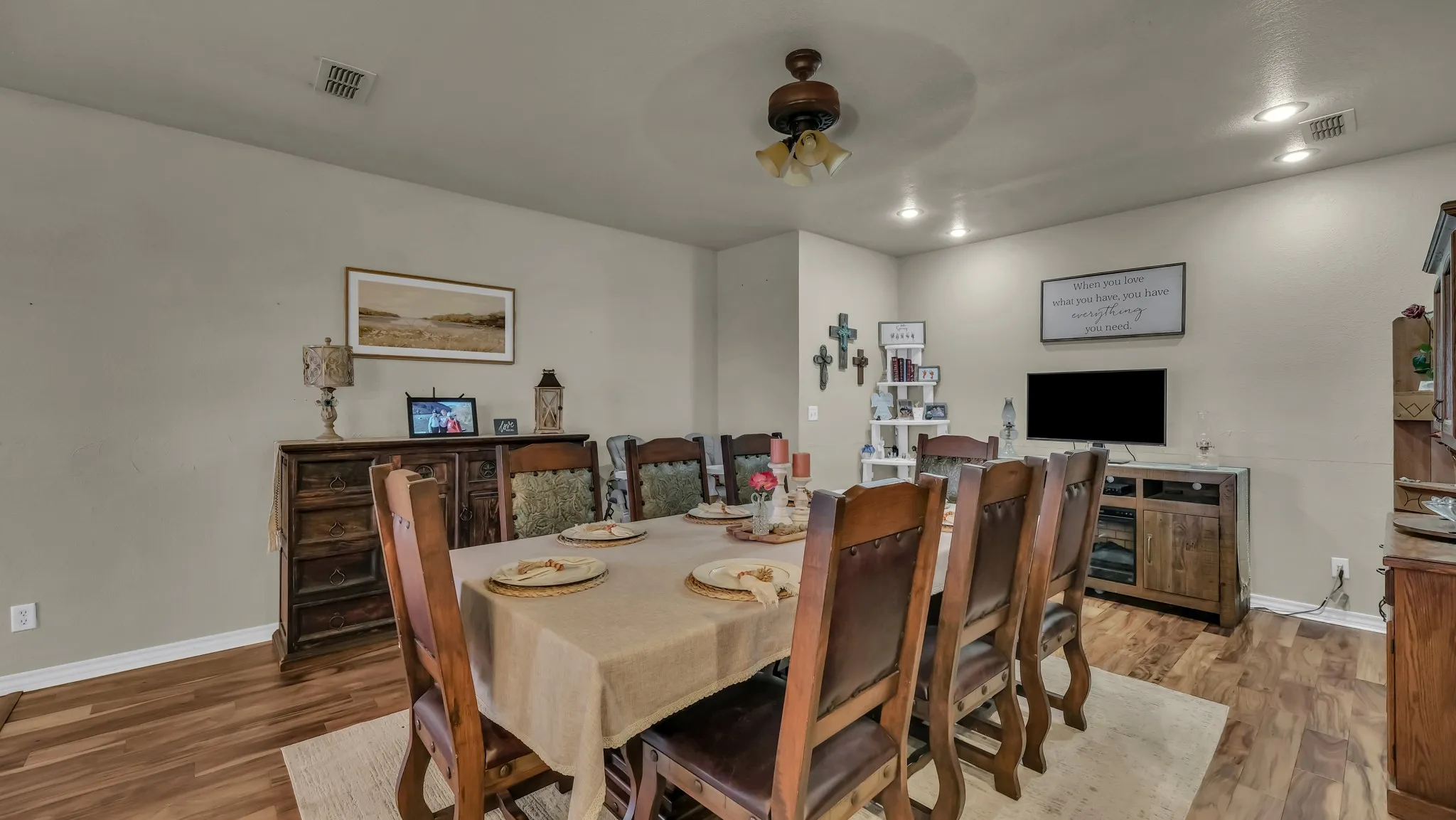 This dining area features wood flooring, a ceiling fan, and recessed lighting