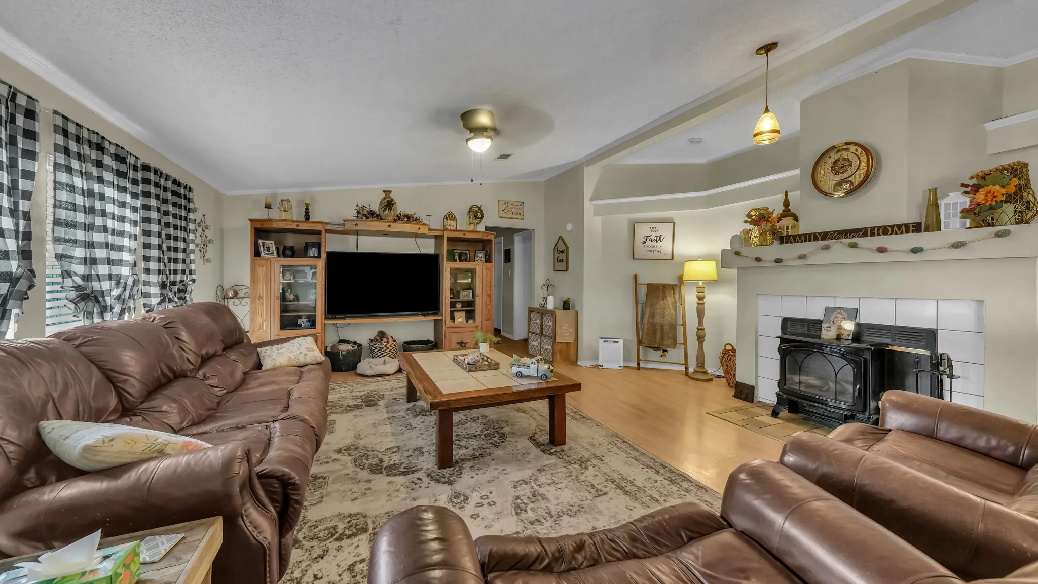 The living area features hardwood floors and a fireplace with a white tile surround