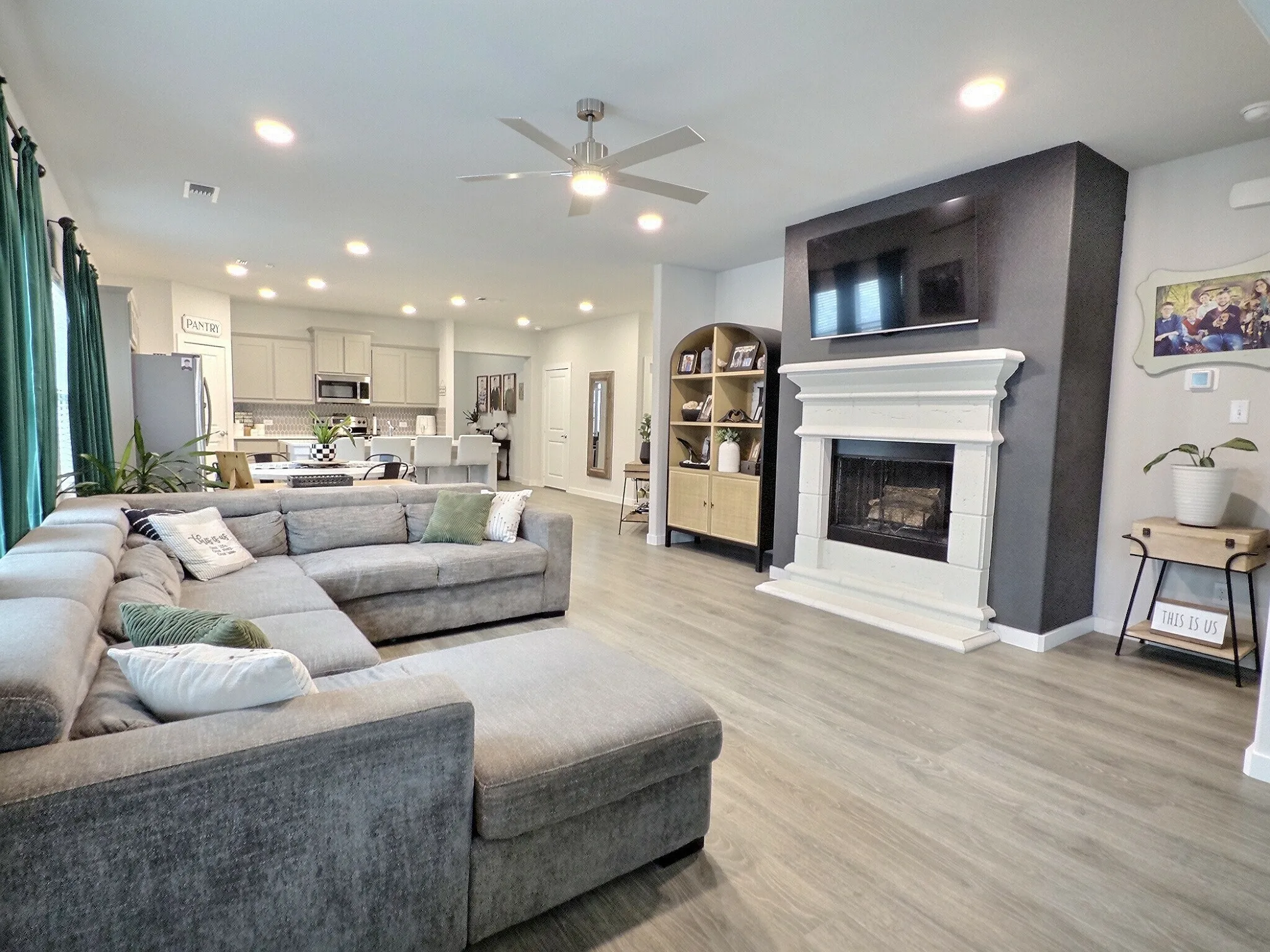 Living area featuring light-toned flooring, a fireplace with a white mantel, and recessed lighting