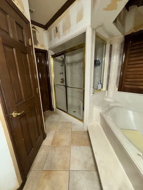 Full bath featuring a bath, ornate columns, ornamental molding, tile patterned flooring, and a stall shower