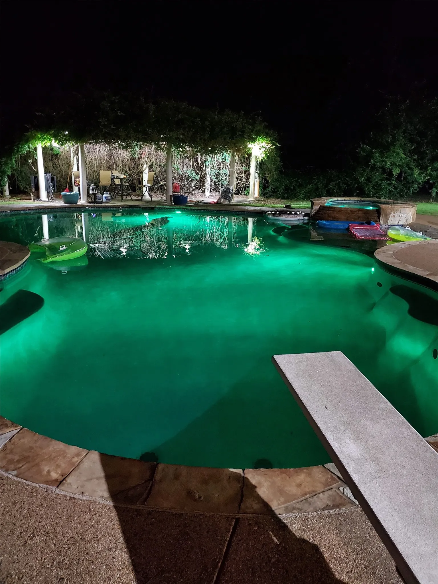 Pool featuring a diving board and a hot tub