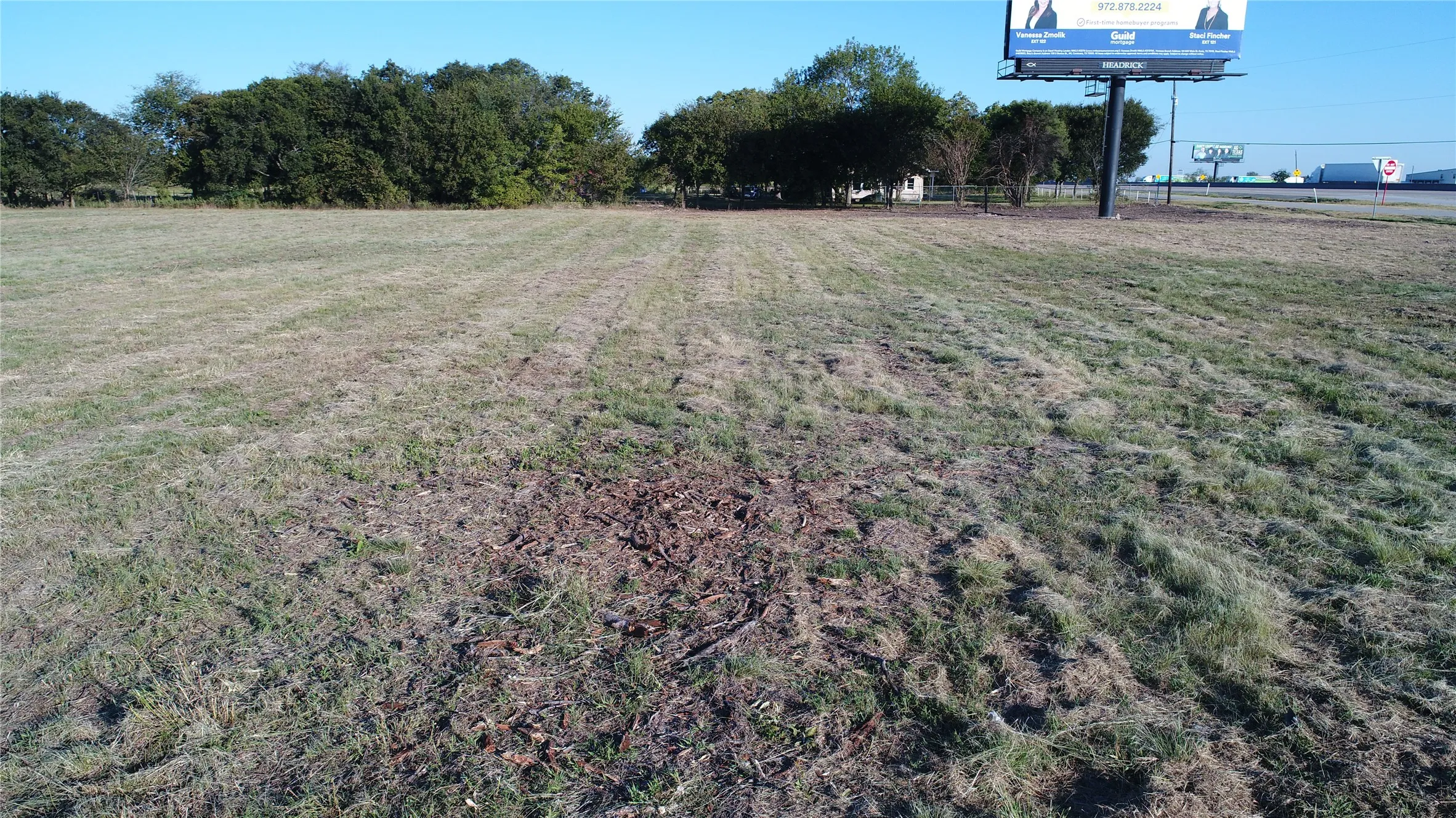 Expansive undeveloped land with a partial tree line visible in the distance