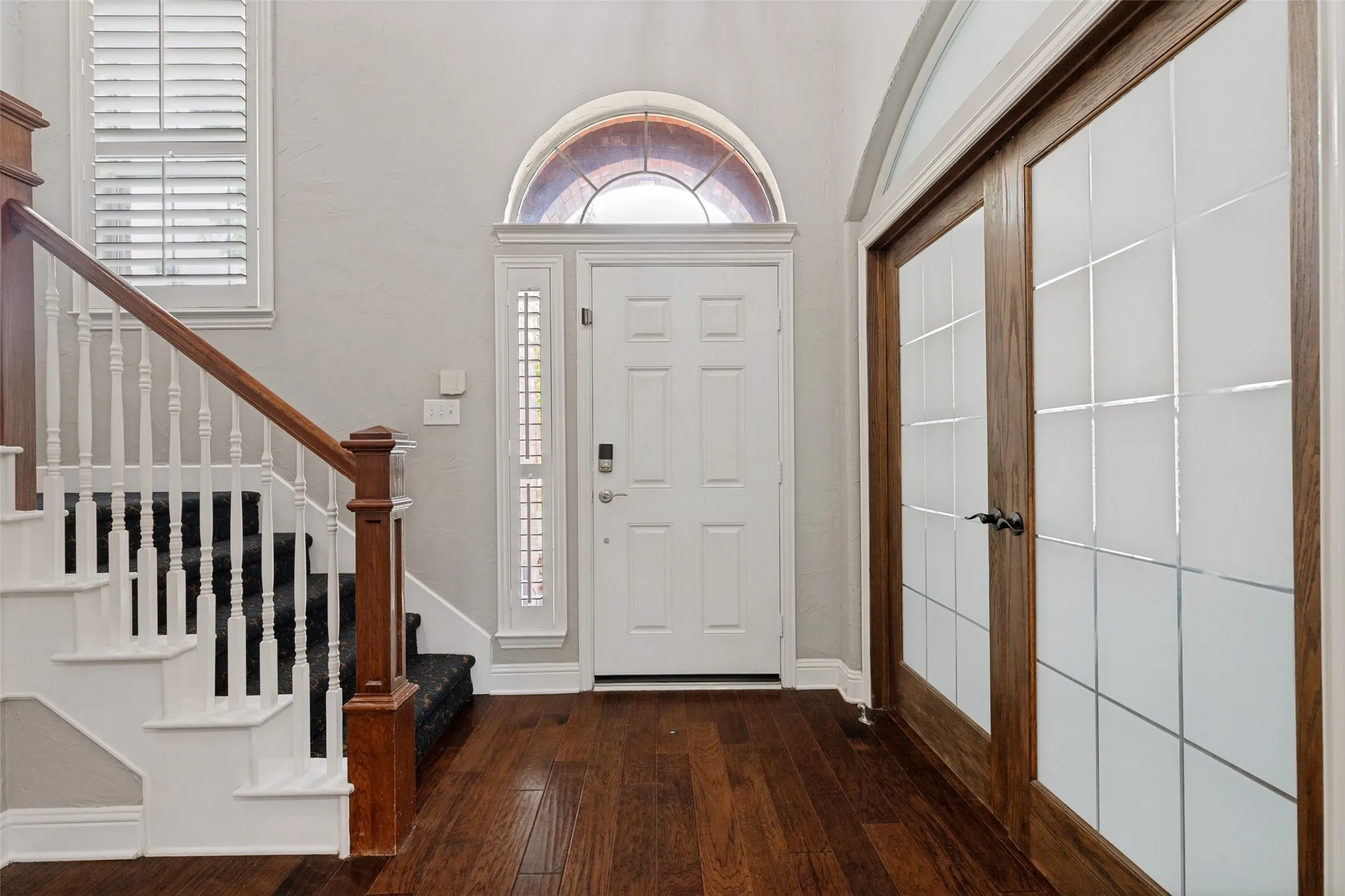 Winding staircase, with designer carpeting, leads upstairs from grand the entry.