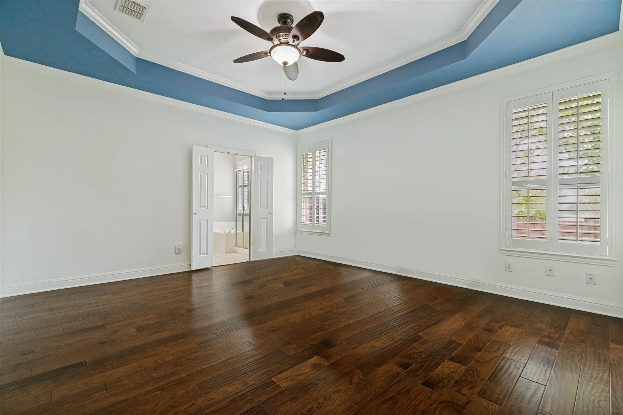 Texas-sized primary bedroom contains tray ceiling accent.