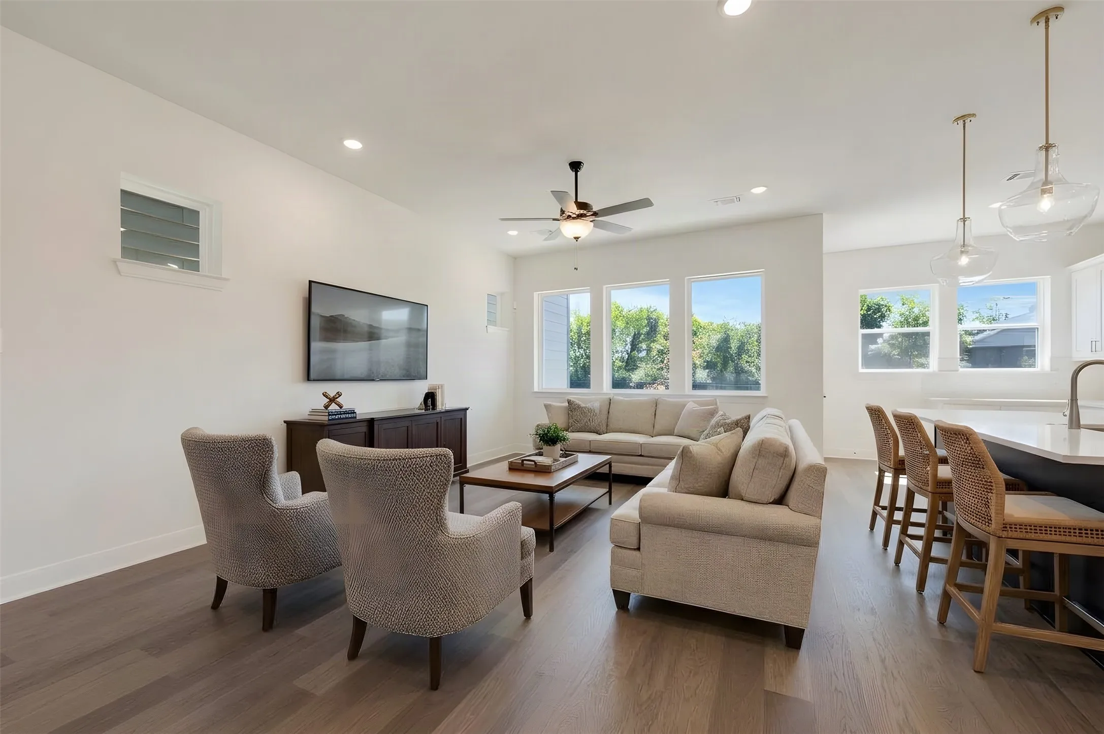 Open-concept living space featuring wood-finish flooring, recessed lighting, and a ceiling fan