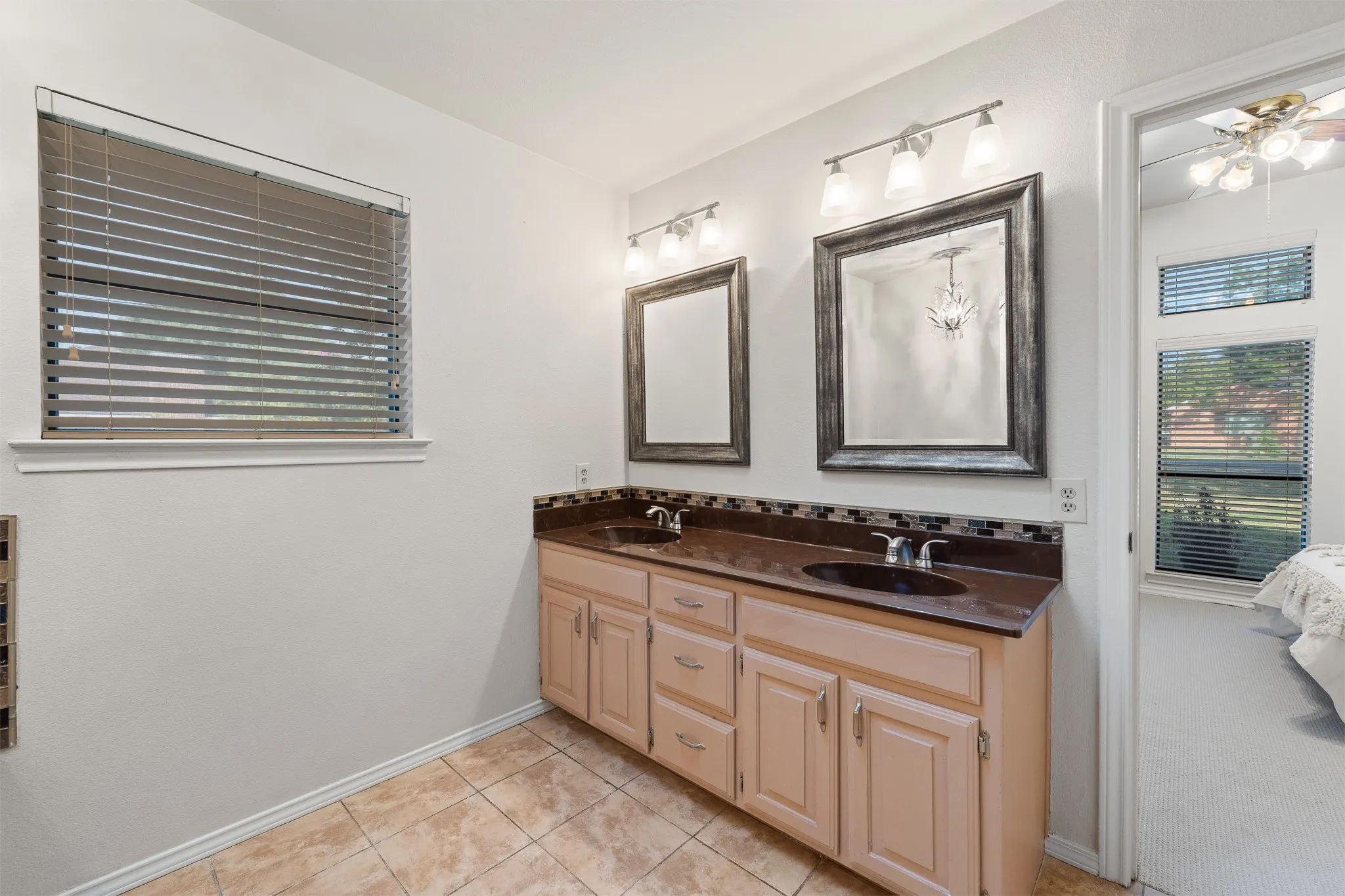 Dual vanity with individual framed mirrors, under-sink storage, and overhead light fixtures