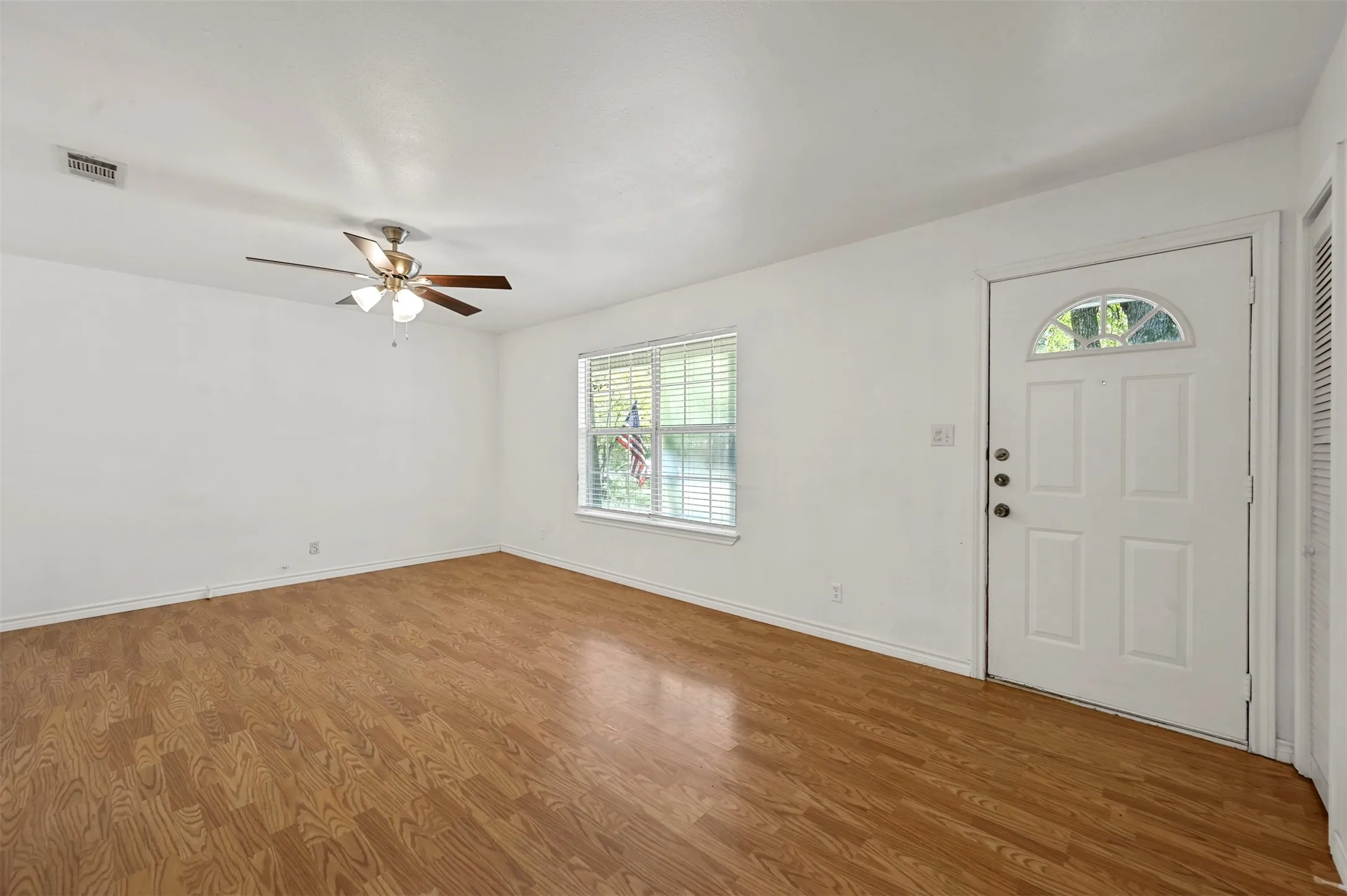Foyer entrance featuring ceiling fan and wood-type flooring