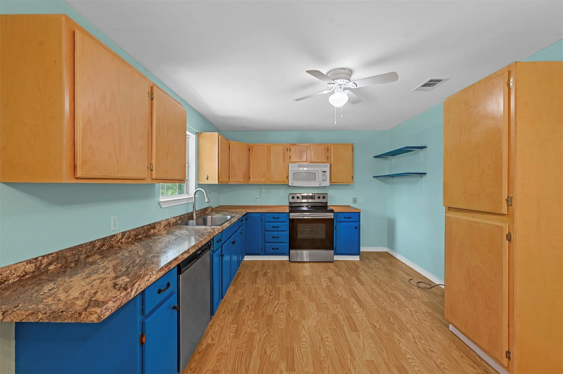 Kitchen featuring ceiling fan, light hardwood / wood-style flooring, sink, and stainless steel appliances