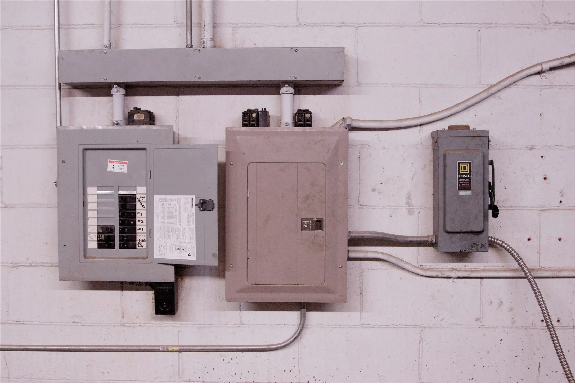 Electrical panel and utility box mounted on a white brick wall