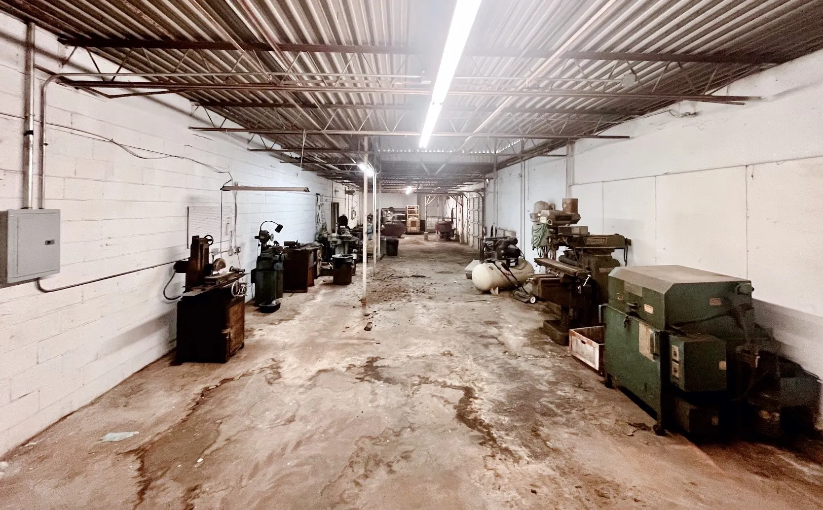 This expansive commercial space features exposed ceiling joists and concrete flooring, offering an adaptable environment for various business needs