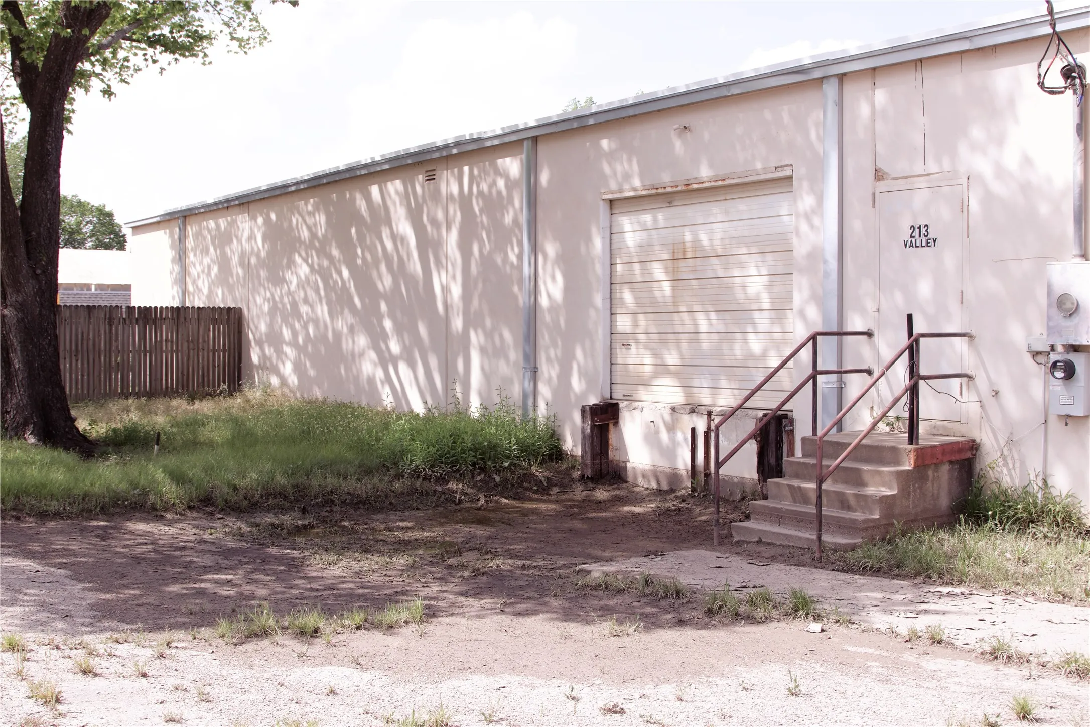 The property features an exterior with a roll-up garage door and a separate entry door with an address clearly visible