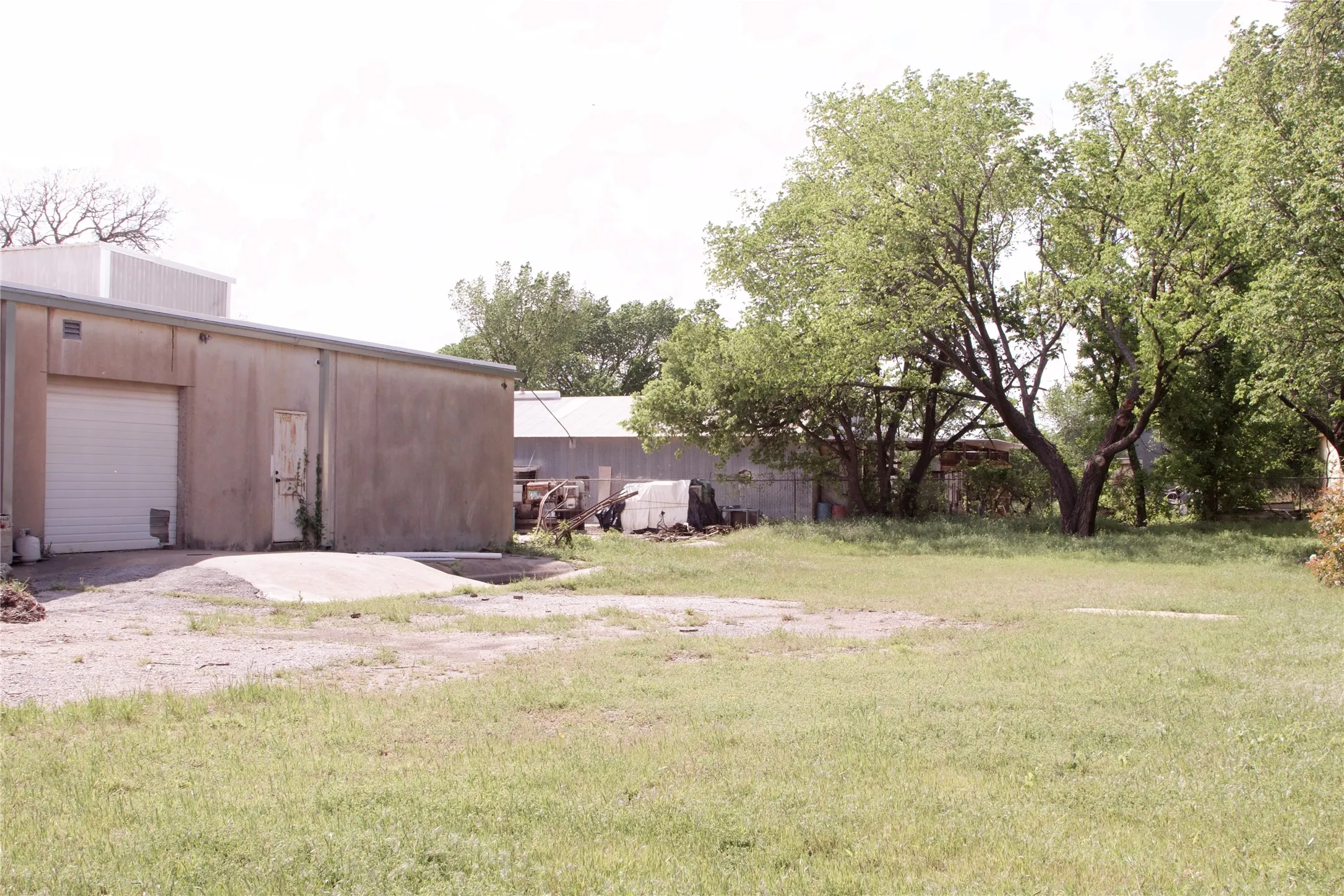 The property features a building with a white roll-up door and an additional entry door