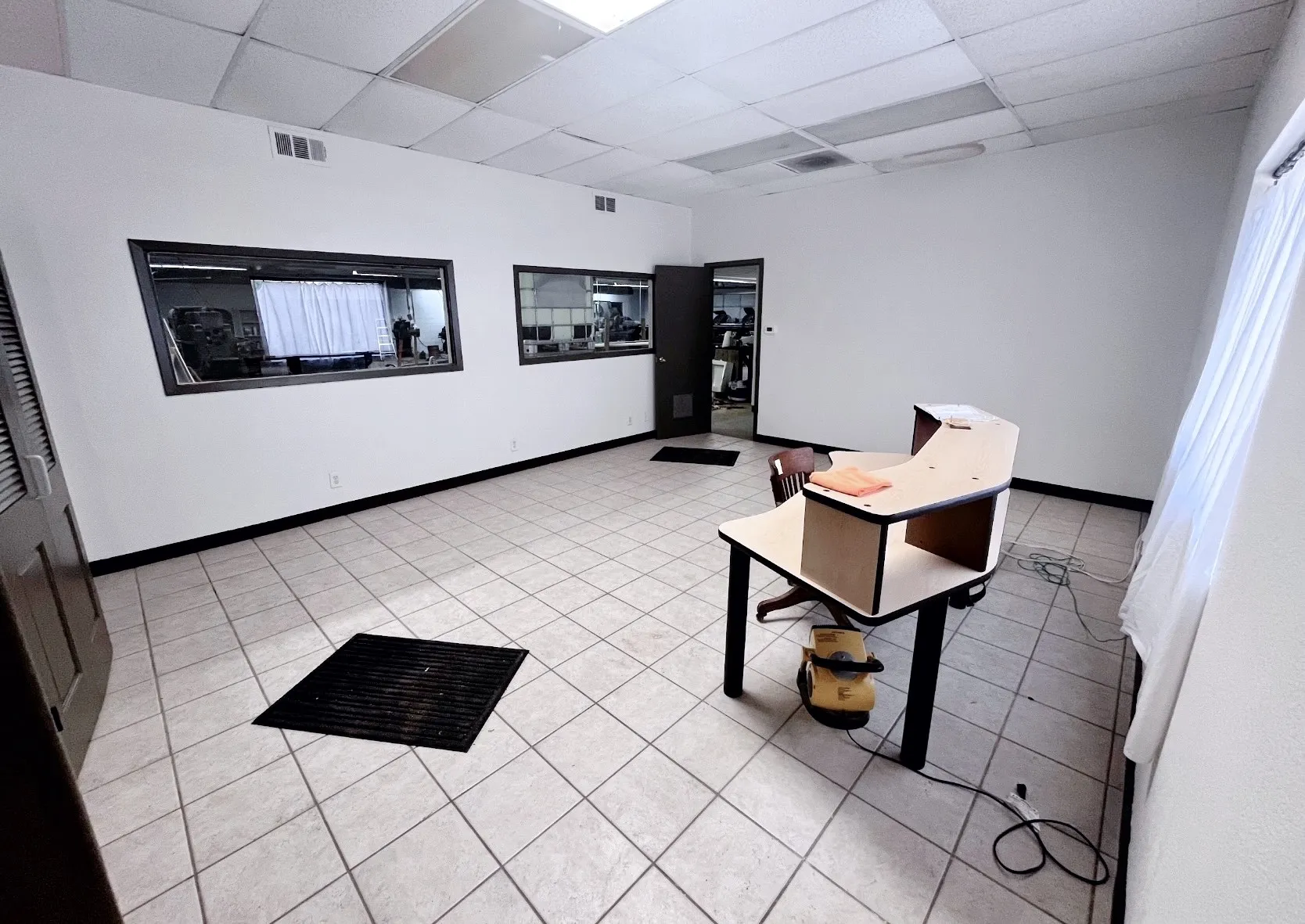 This expansive commercial space features tiled flooring and white walls, offering a versatile environment
