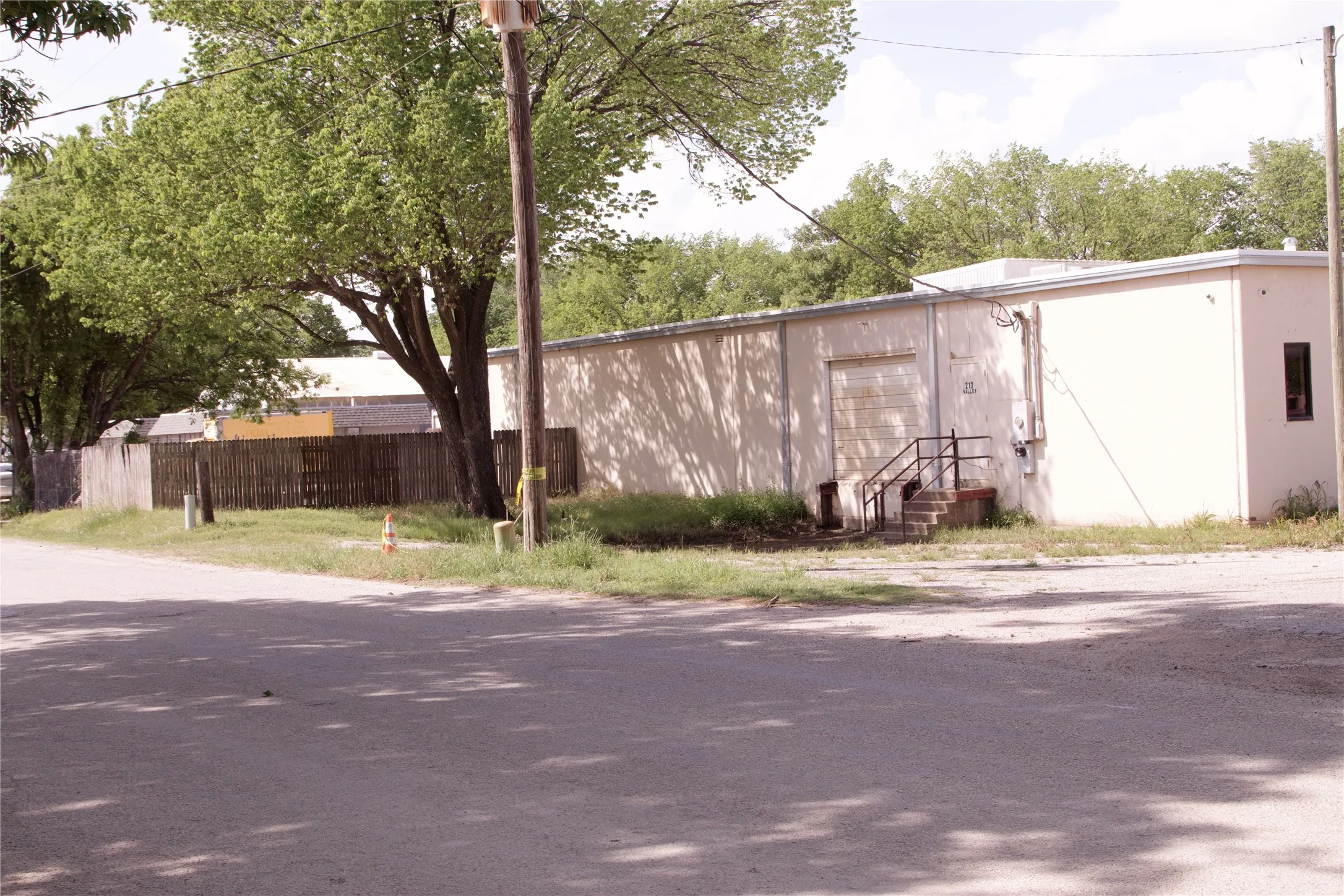 The property includes a single-story building with a garage door and an exterior staircase