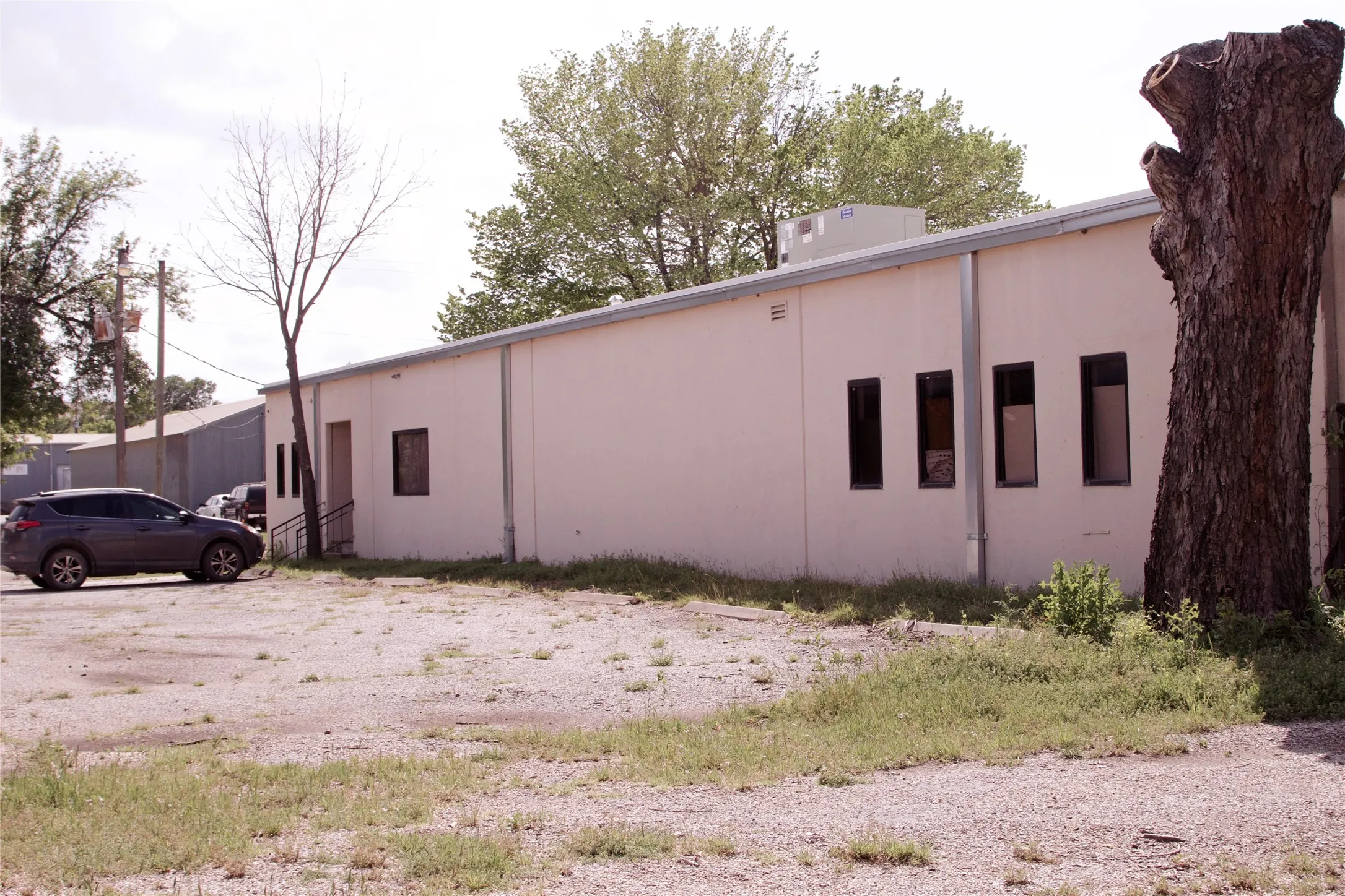 The property features a large, light-colored building with multiple windows