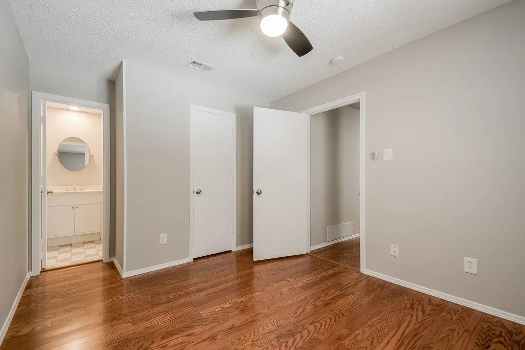 This room features hardwood floors and a ceiling fan