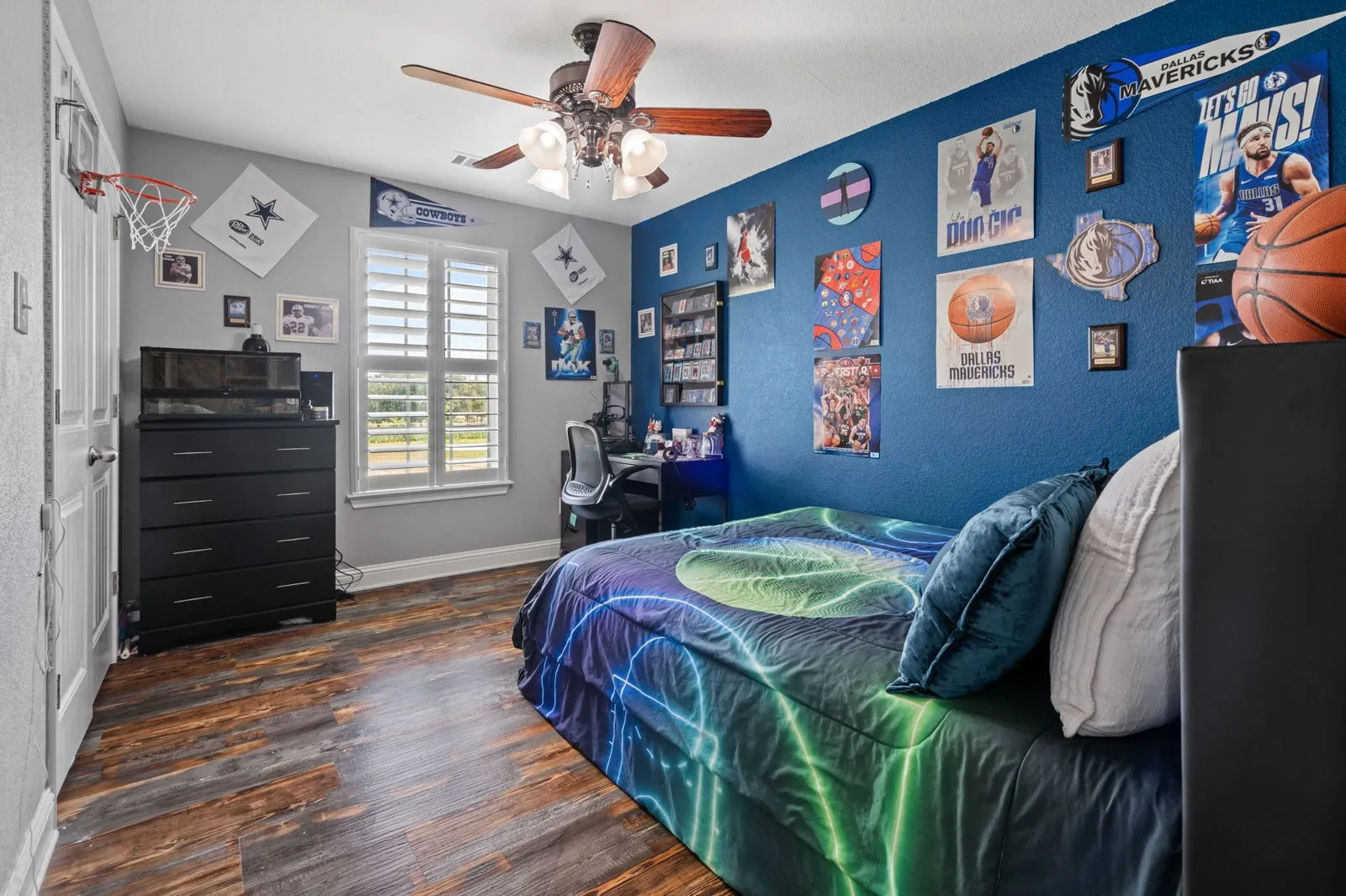 Spacious secondary bedroom featuring warm farmhouse-inspired luxury vinyl floors, great natural light from a window with scenic views, a walk-in closet, and a ceiling fan.