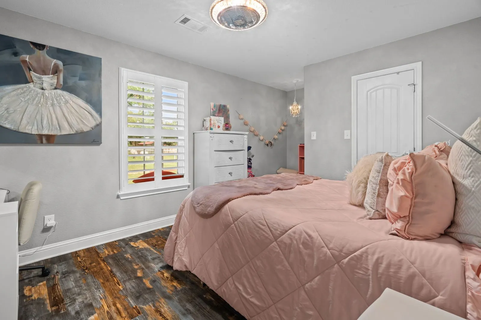 Another spacious secondary bedroom featuring warm farmhouse-inspired luxury vinyl floors, great natural light from a window with scenic views, a walk-in closet, and beautiful lighting.