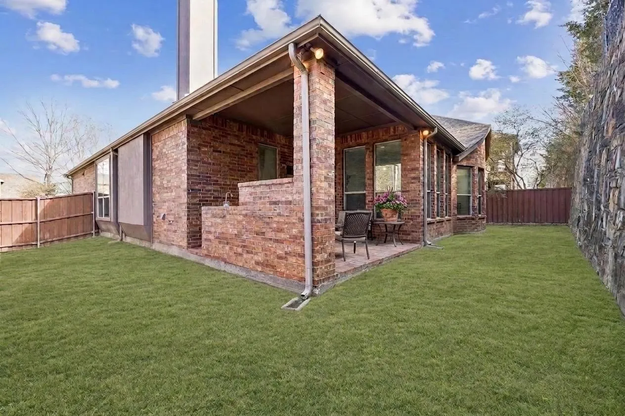 Covered outdoor living, brick construction, and a manageable yard built for ease.