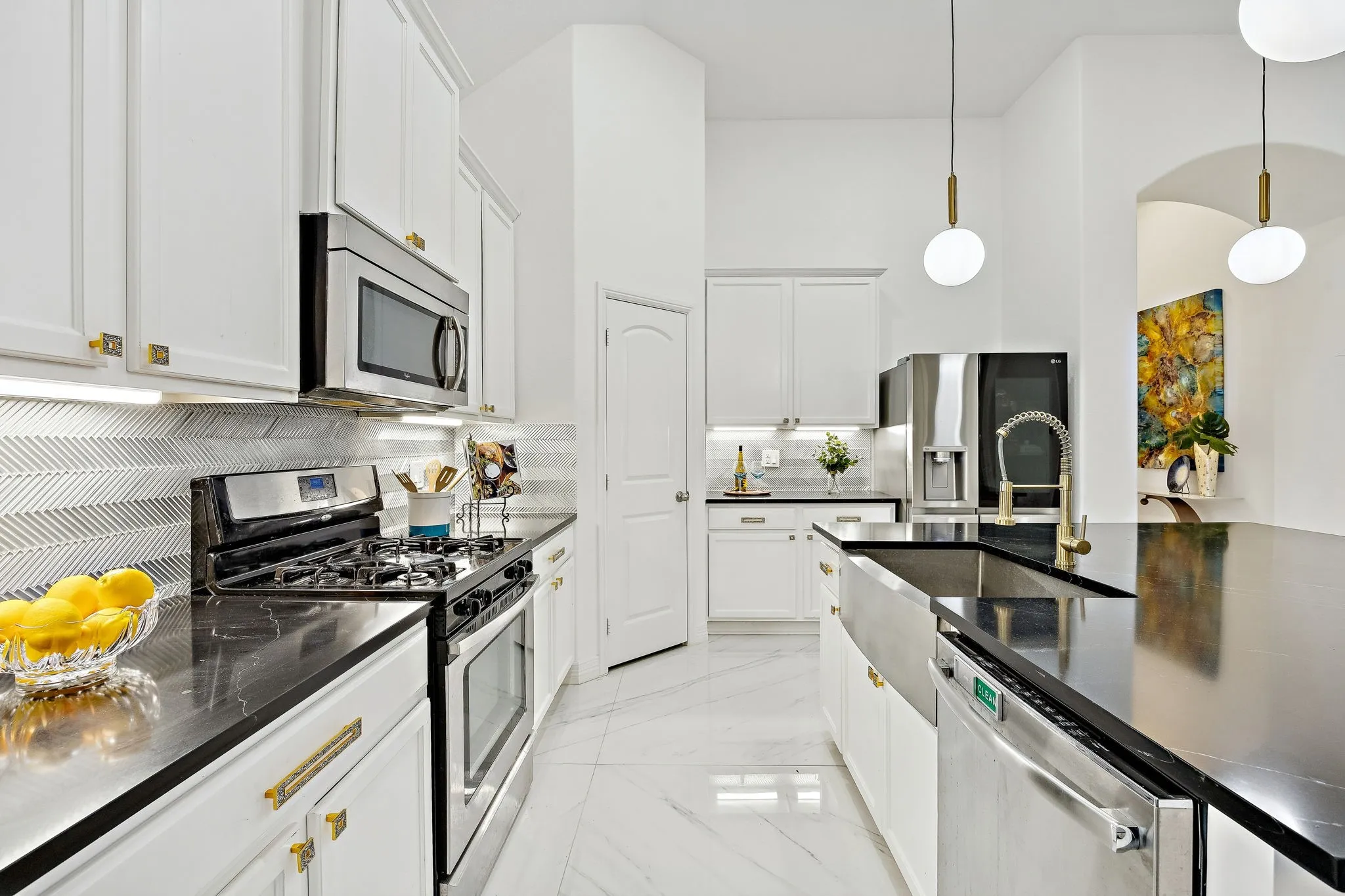Updated kitchen details include quartz counters, mosaic backsplash, under-cabinet lighting, and stylish hardware.