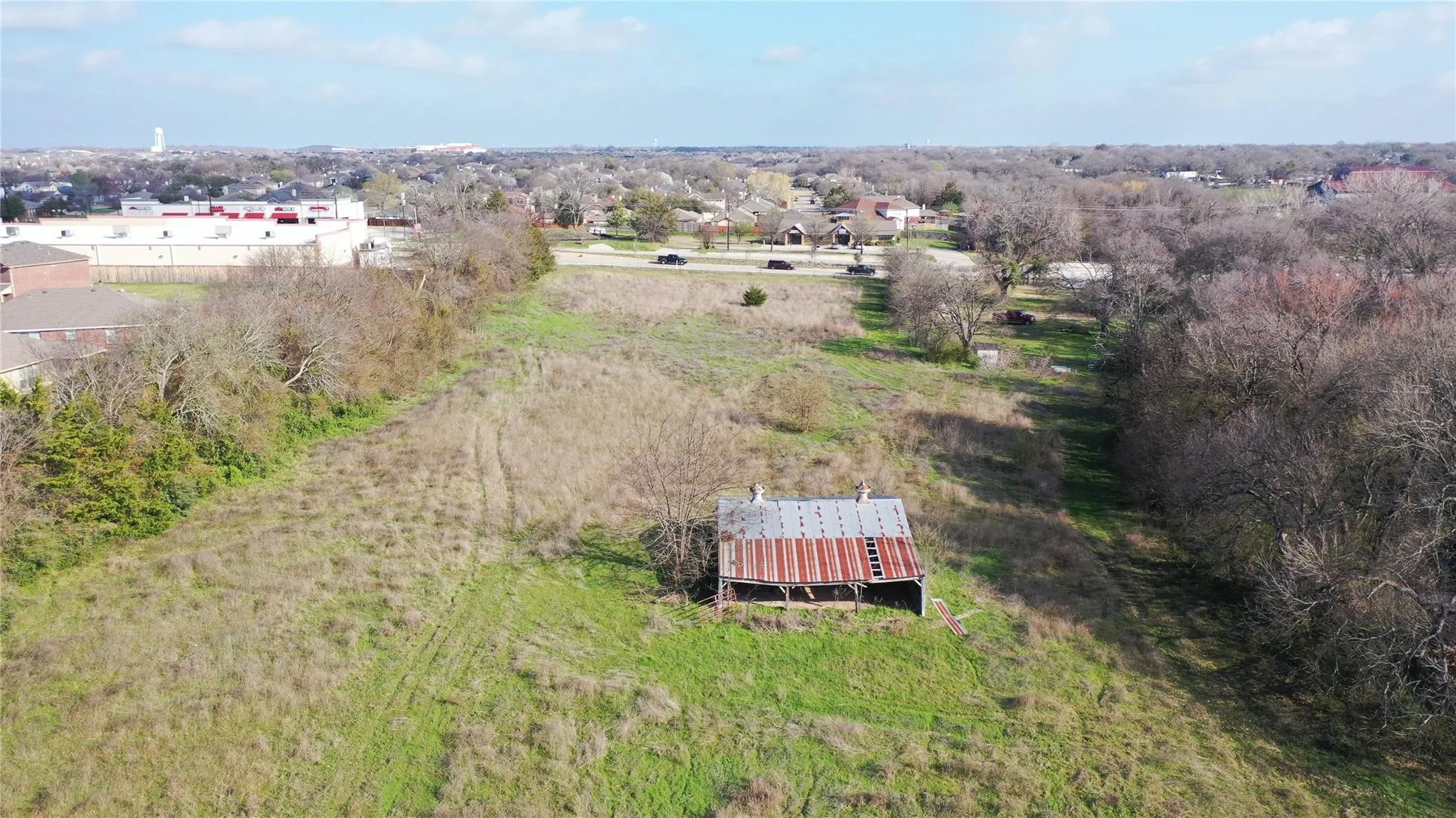 Expansive property featuring a large open field with natural vegetation