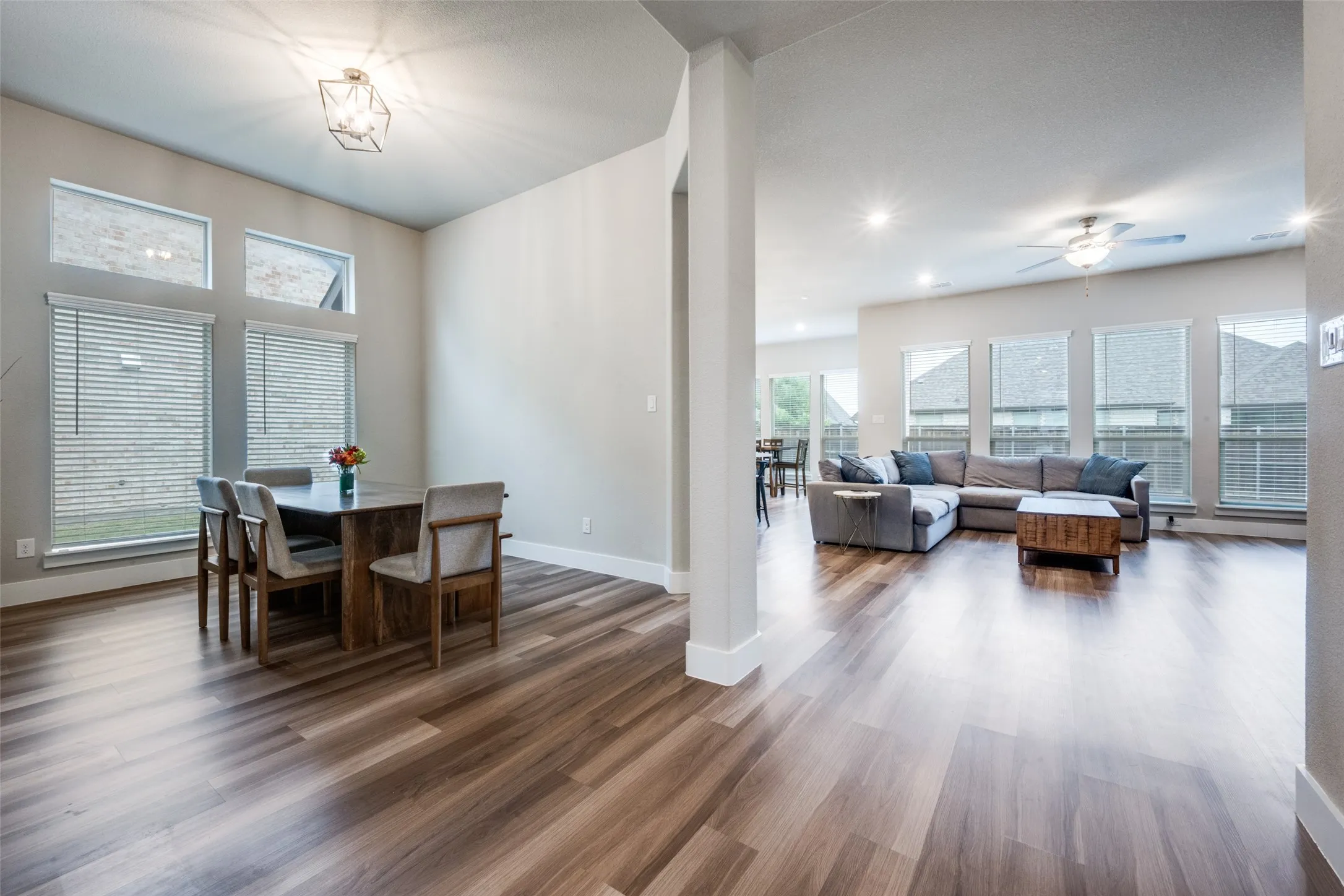 The open-concept living space features a huge living room just off the formal dining and kitchen, with ample natural lighting from the large windows.