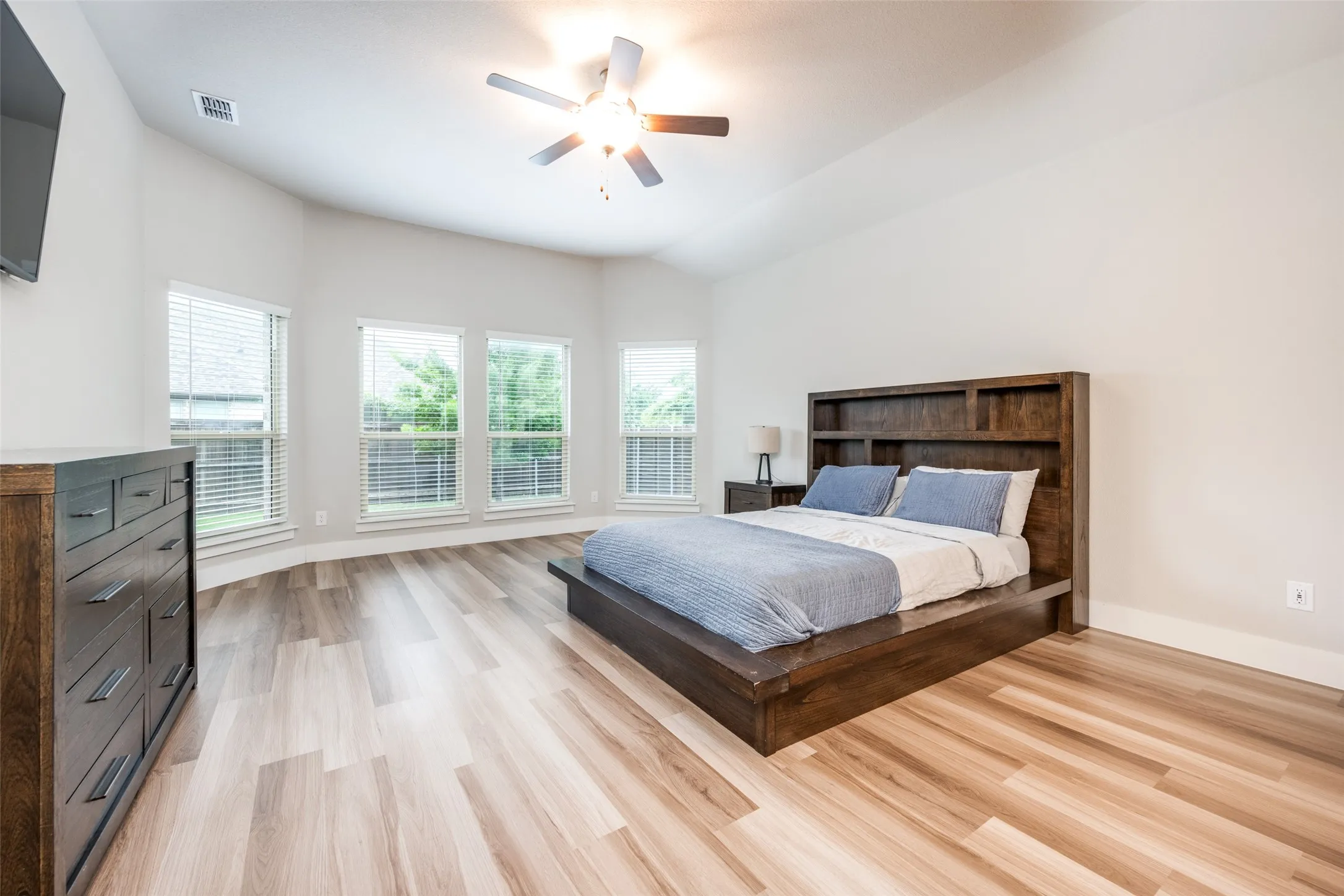 The spacious primary suite has plenty of room for a large bed (queen shown) and furniture plus bay windows perfect for a sitting area.