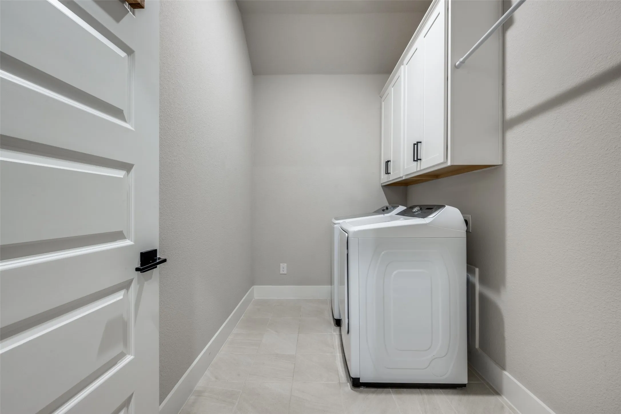 The laundry space is designed to accomodate the whole process in one room. Wash, dry, fold, hang. Or maybe keep an extra refrigerator/freezer in here.
